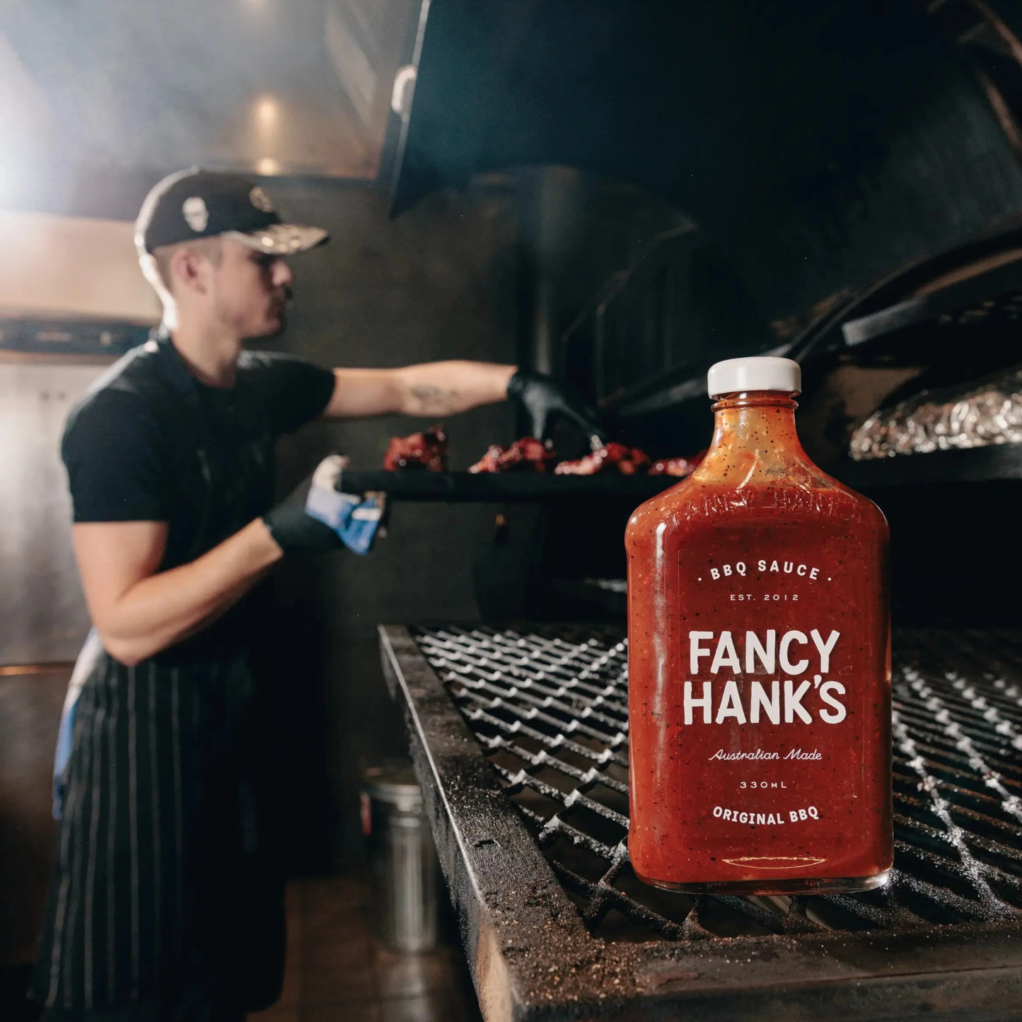 Fancy Hanks Original BBQ Sauce 330ml on a grilling rack, which is a slow-cooked American style barbecue sauce that is tangy, rich and molasses layered depth.