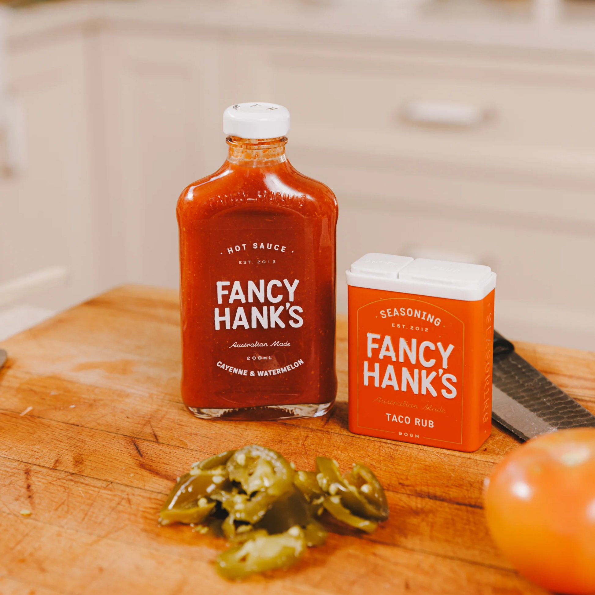 On the table with a hot sauce bottle, the Fancy Hanks Taco Rub 90g, a bold vegan friendly spice blend for tacos, and anything that needs a flavour hit. No preservatives added.