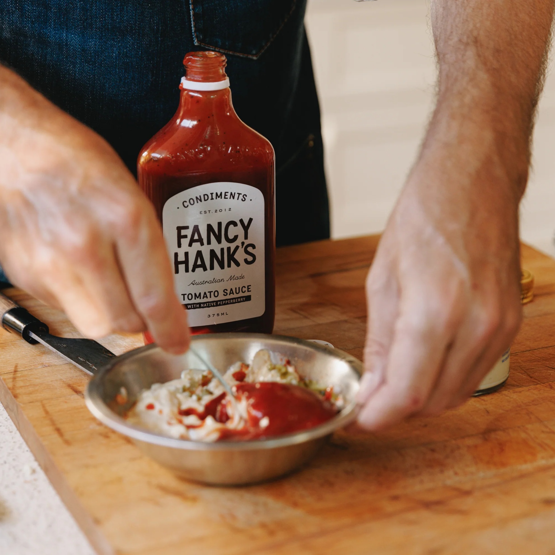 Making sauce with the Fancy Hanks Tomato Sauce 330ml, a classic Australian tomato sauce with Australian-grown tomatoes, malt vinegar and Tasmanian Mountain Pepper.