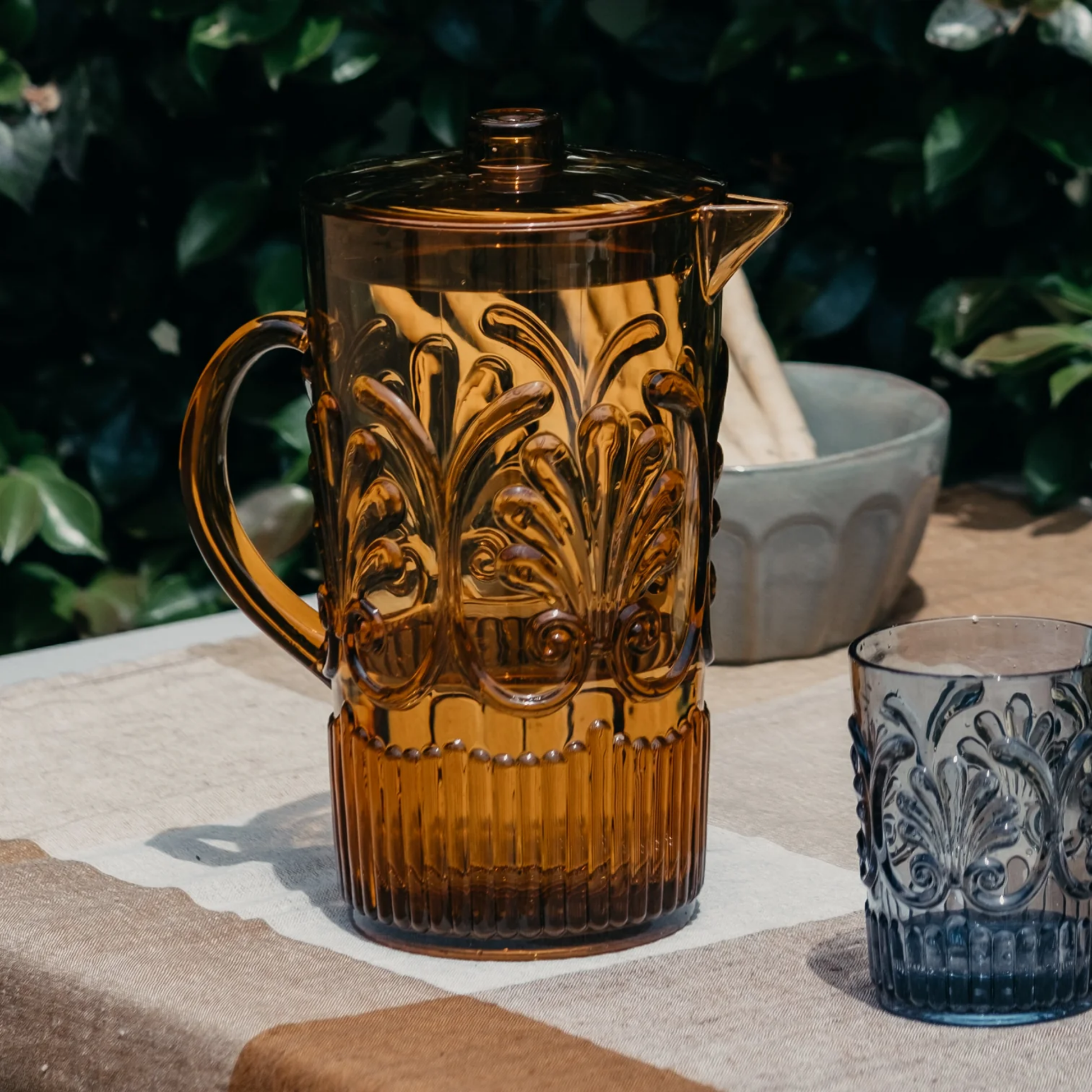 Amber acrylic jug on set picnic table outside