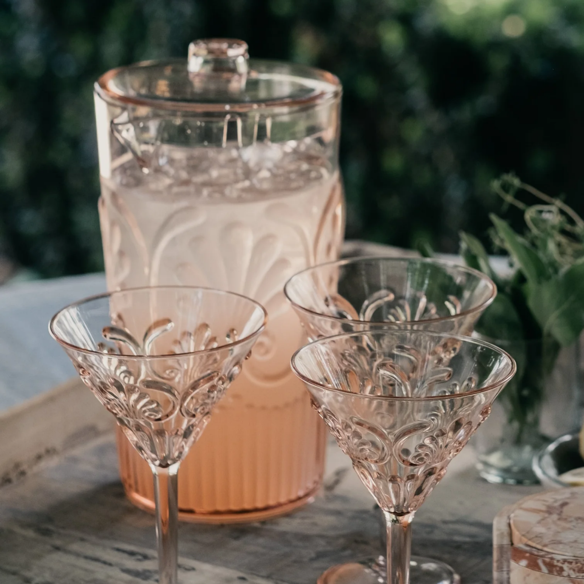 Pale pink acrylic jug pink on outdoor table with acrylic glassware