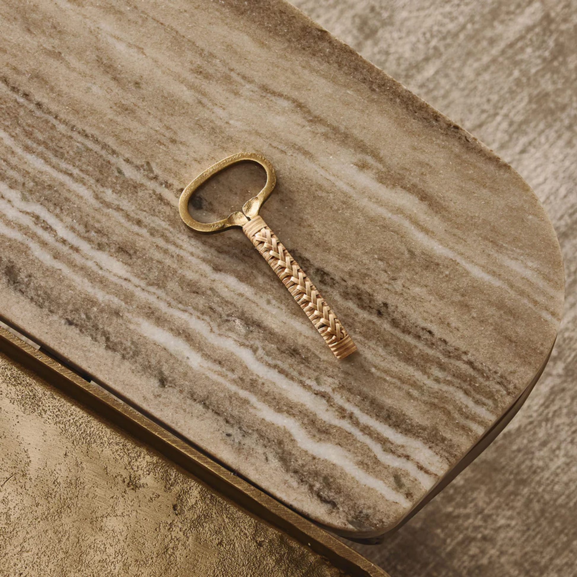 Bamboo and brass bottle opener - natural brown bamboo handle with antique brass iron accents; handcrafted, 13 cm long, elegant and functional bar or kitchen accessory. Shown on a wood.