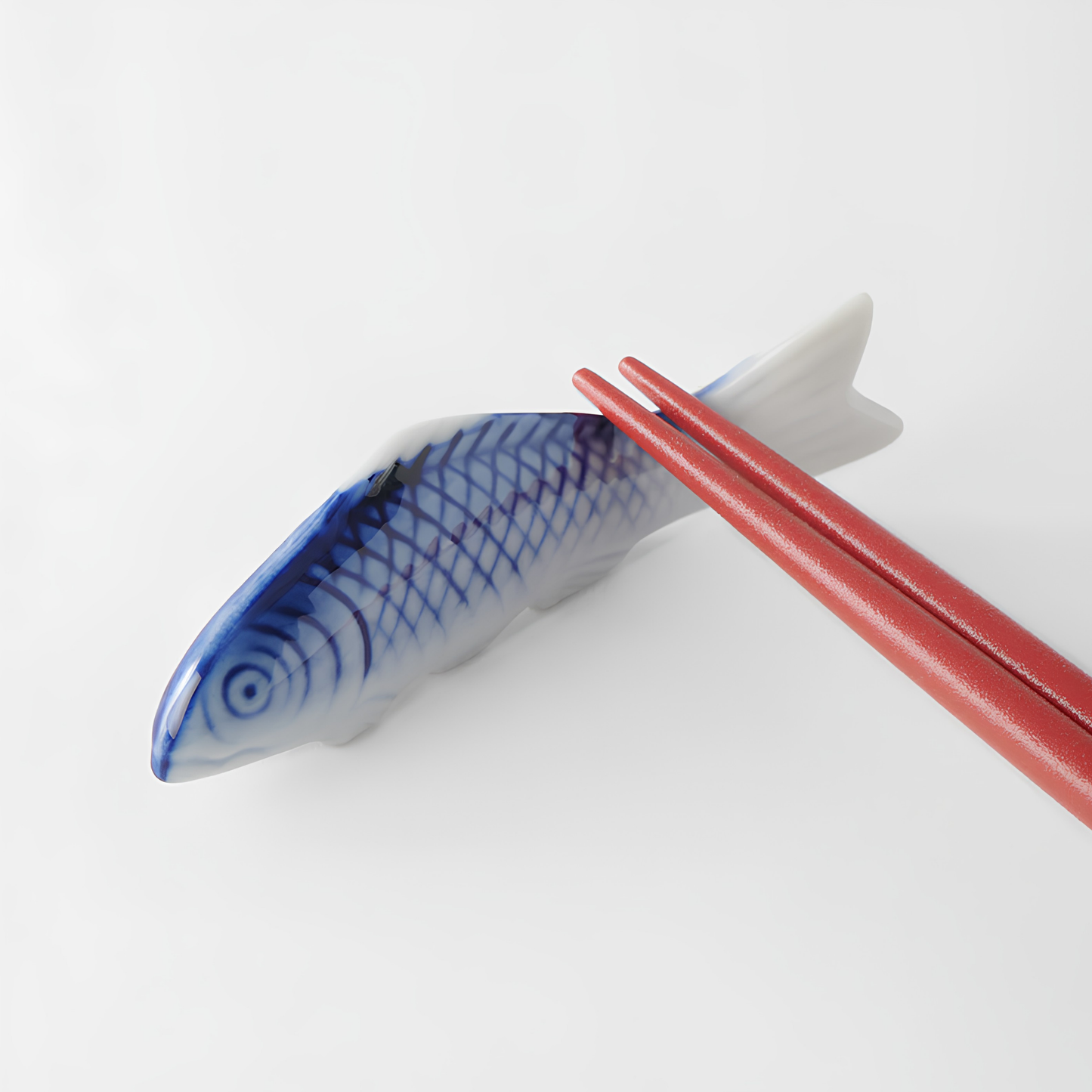 Another way of resting the chopsticks which is in the tail when standing with Fathom Chopstick Rest Blue Fish that has slight irregularities in size, glaze and texture from the artisan of the product
