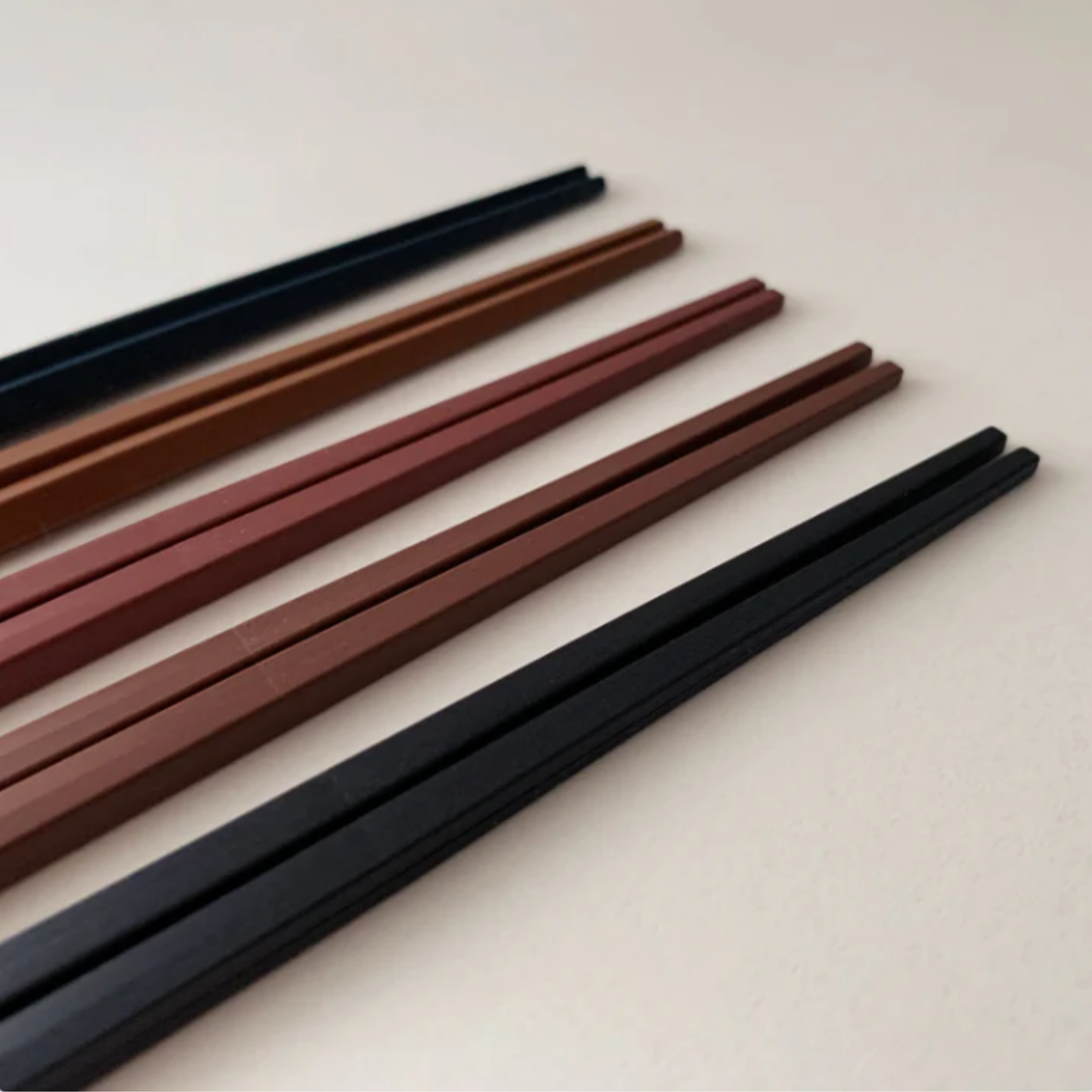Showing the tips of chopsticks from Fathom Kyoto Chopsticks Set of 5 - Timber-tone resin chopsticks, 23cm long, hexagonal shape with matte finish for non-slip grip, dishwasher safe.