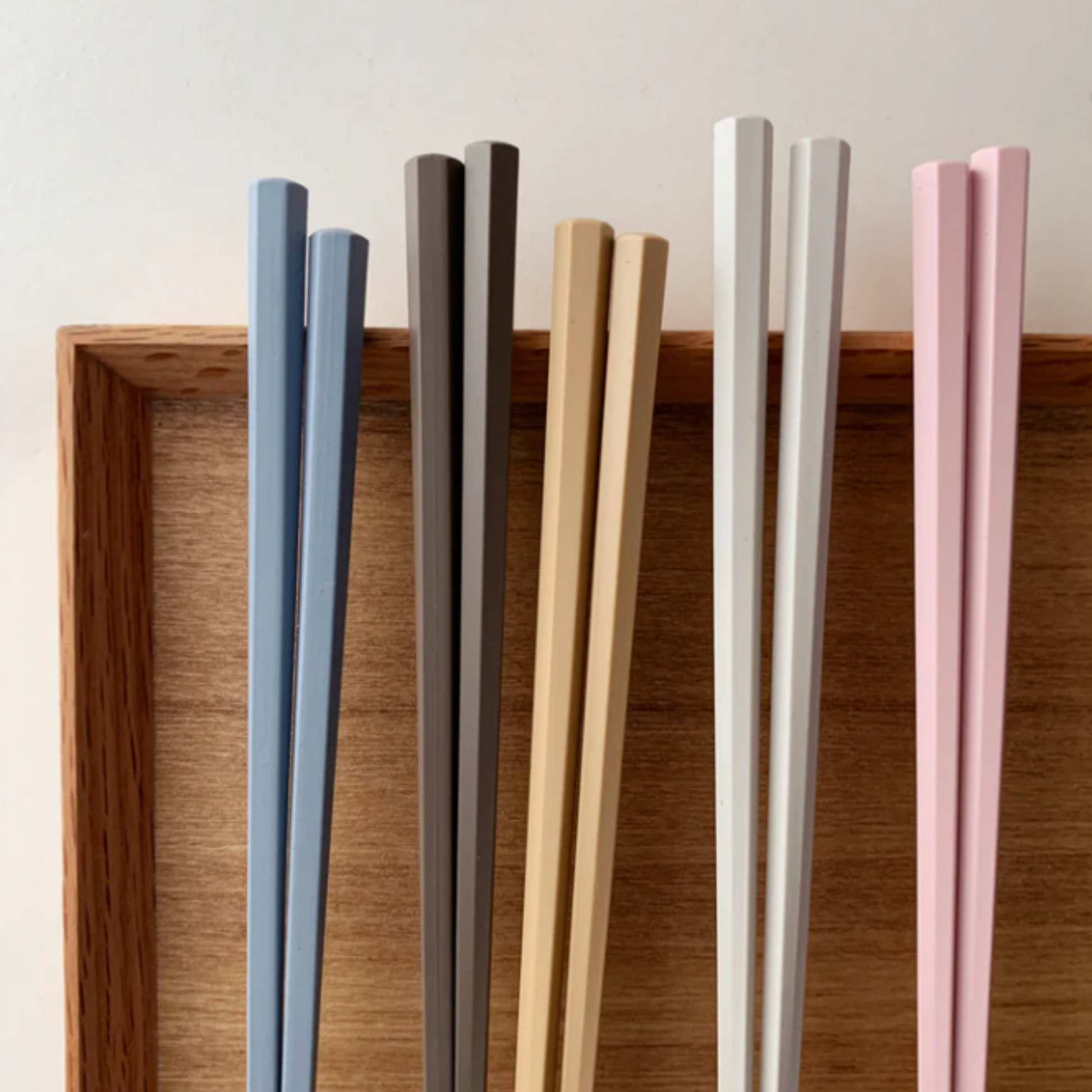 Showing chopsticks on a wooden plate, Fathom Tokyo Chopsticks Set of 5 - Pastel resin chopsticks, 23cm long, hexagonal shape with matte non-slip finish, lightweight, dishwasher safe.