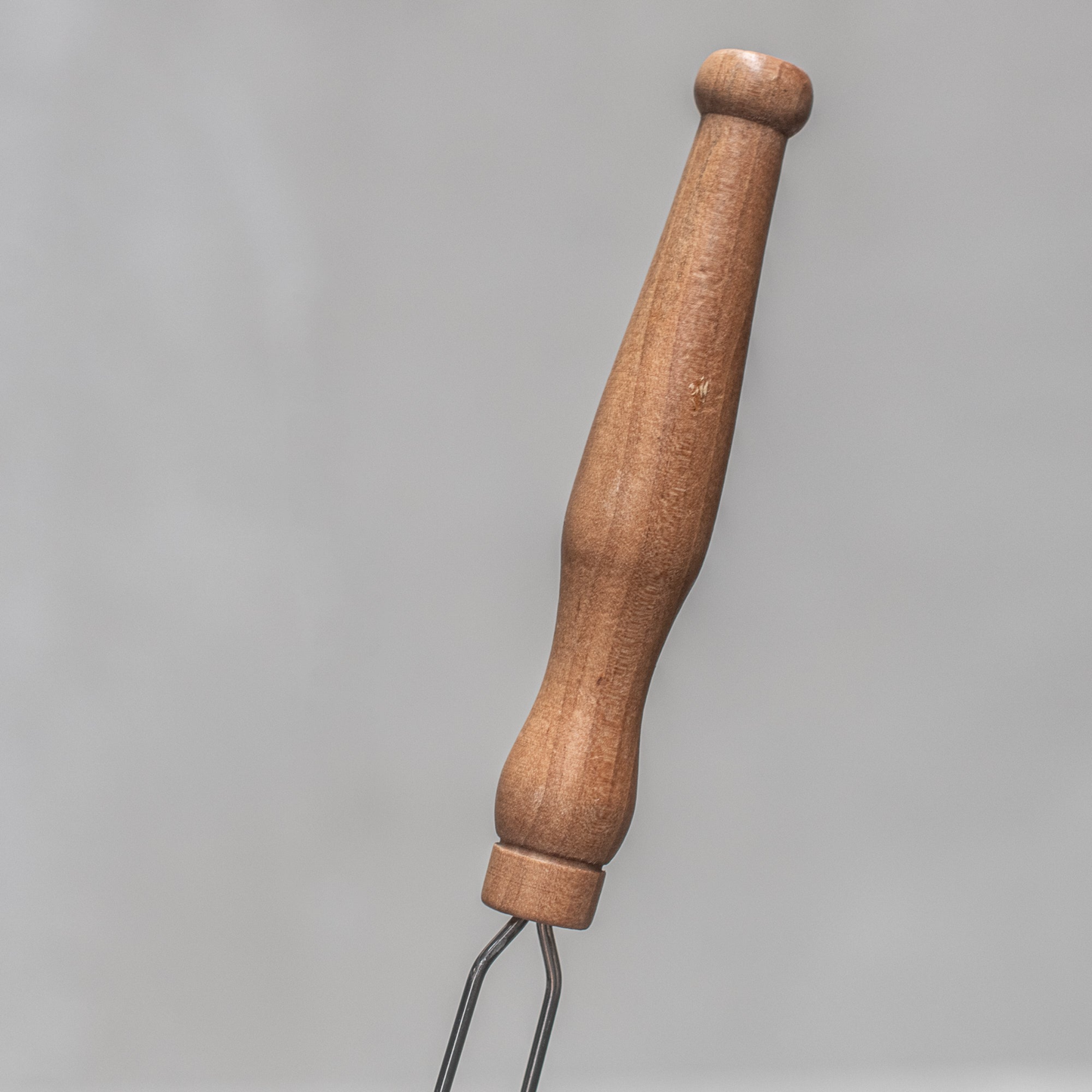 The wooden handle of Fathom French mesh fly swatter with natural handle, 54cm lightweight insect control tool for indoor and outdoor use in kitchens, patios, and dining areas.