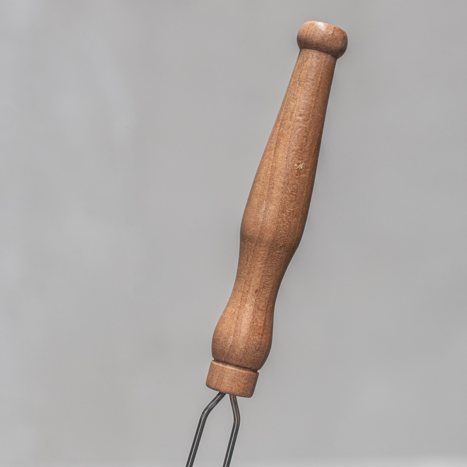 The wooden handle of Fathom French mesh fly swatter with natural handle, 54cm lightweight insect control tool for indoor and outdoor use in kitchens, patios, and dining areas.