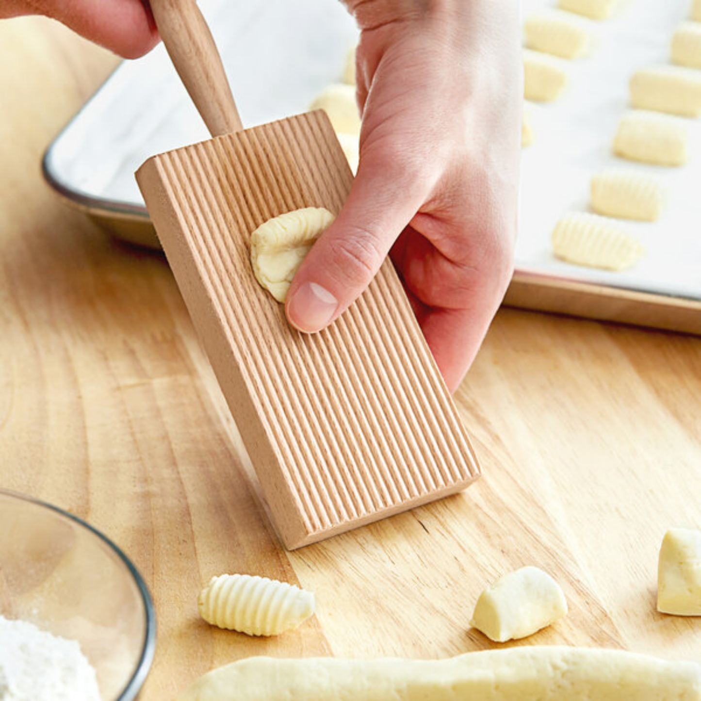Man using wooden gnocci board on wooden countertop
