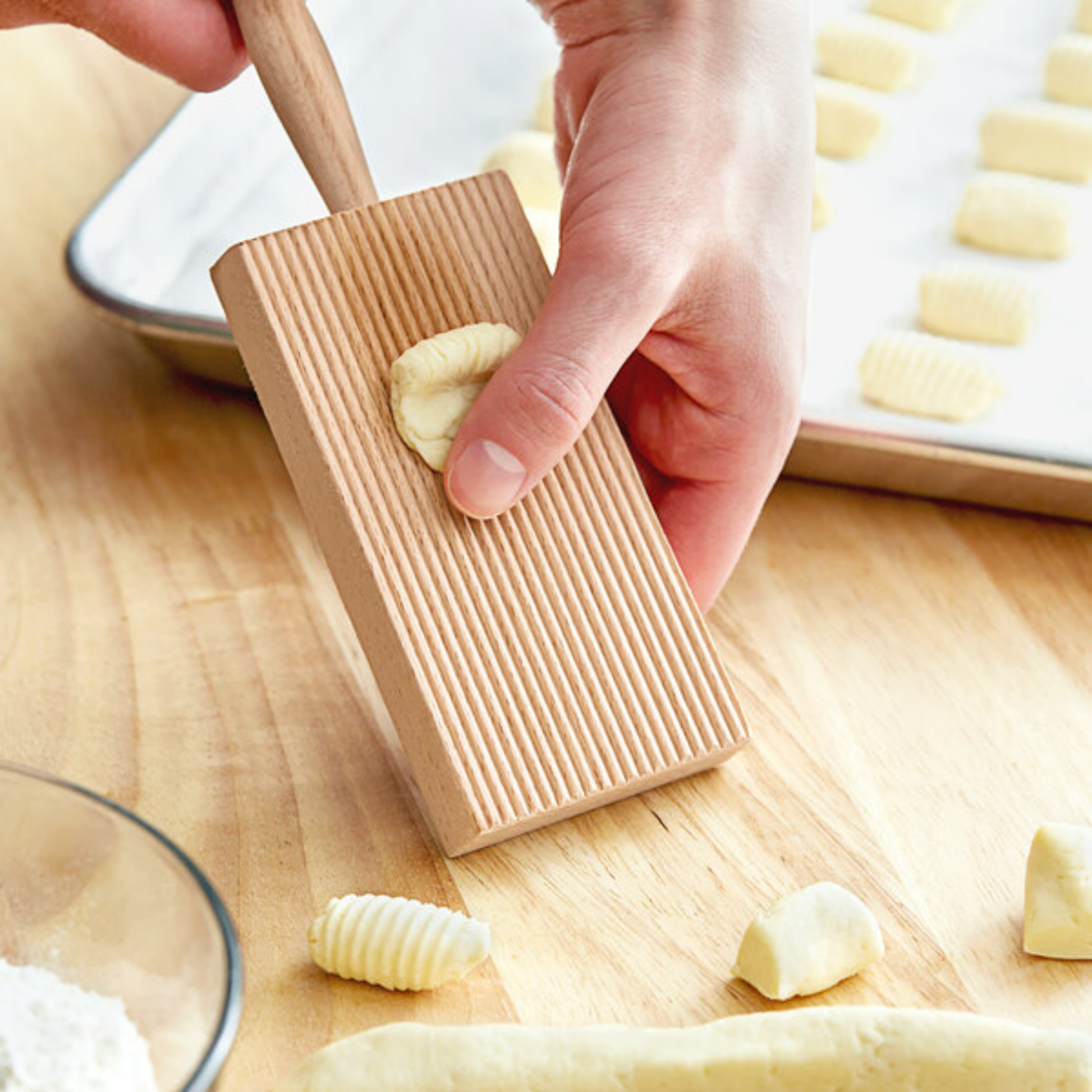 Man using wooden gnocci board on wooden countertop
