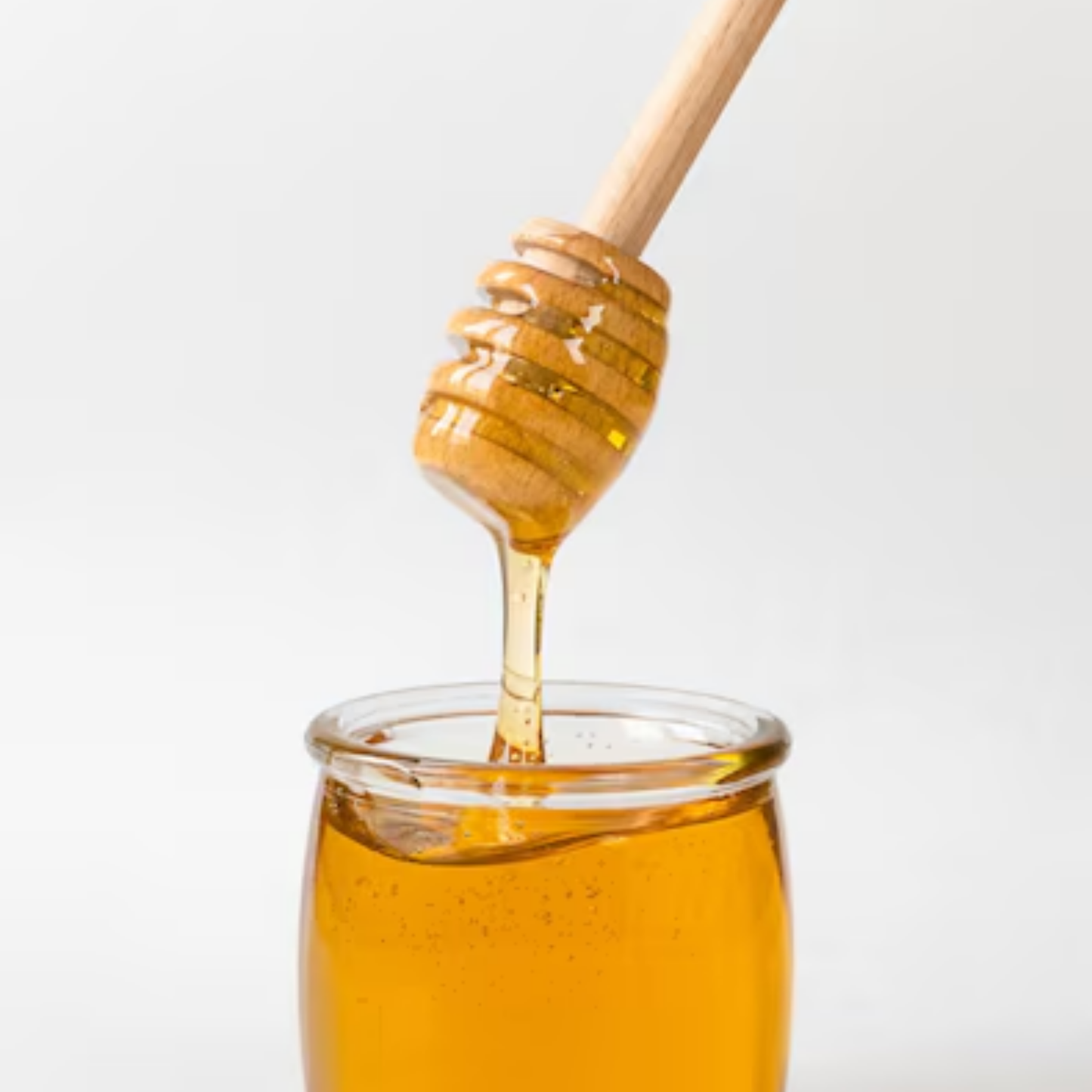Honey dripper spooing honey out of jar close up