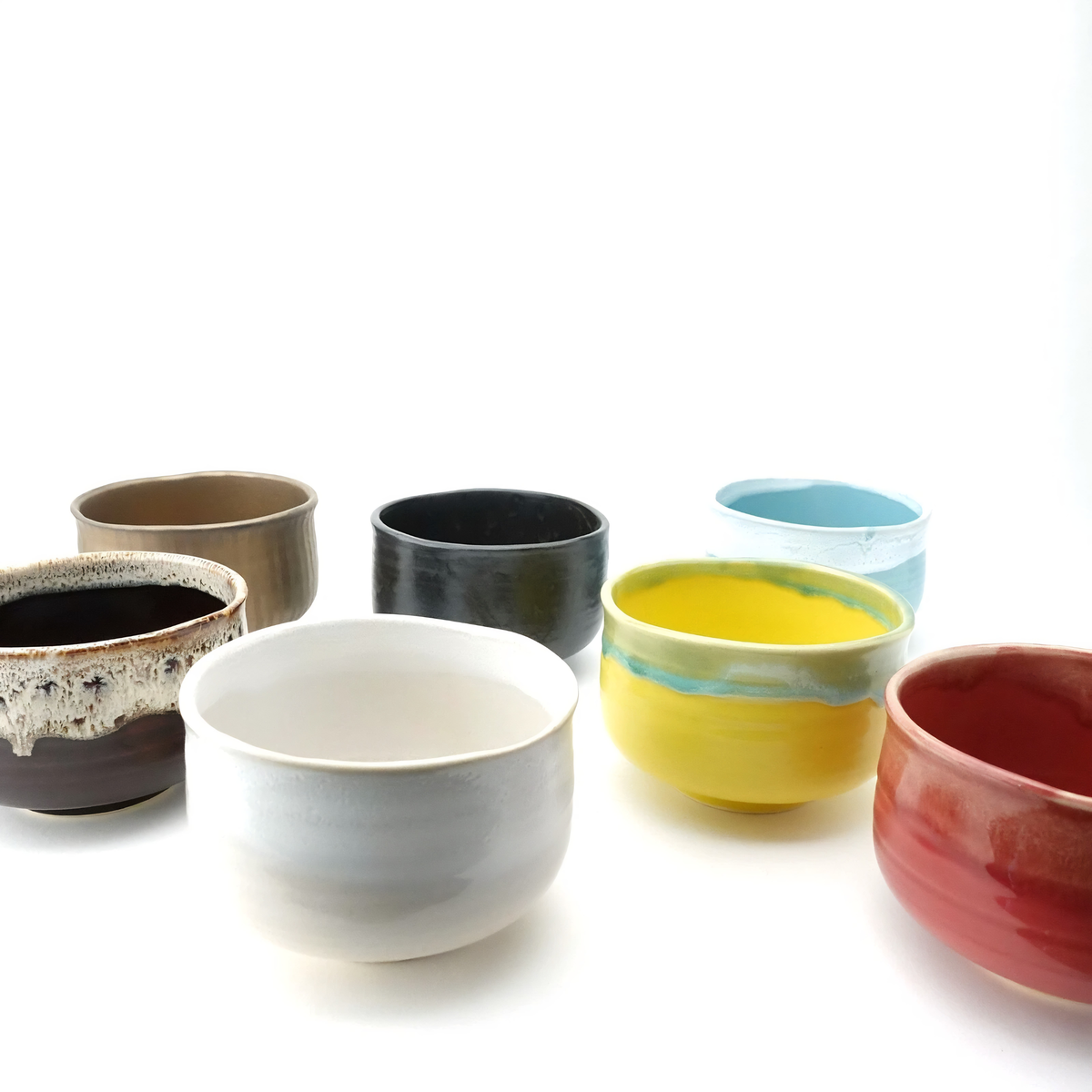 Various bowls, with the Fathom Japanese Hasami Ware Matcha Bowl in amber, ceramic with textured finish, compact lightweight design for casual matcha.
