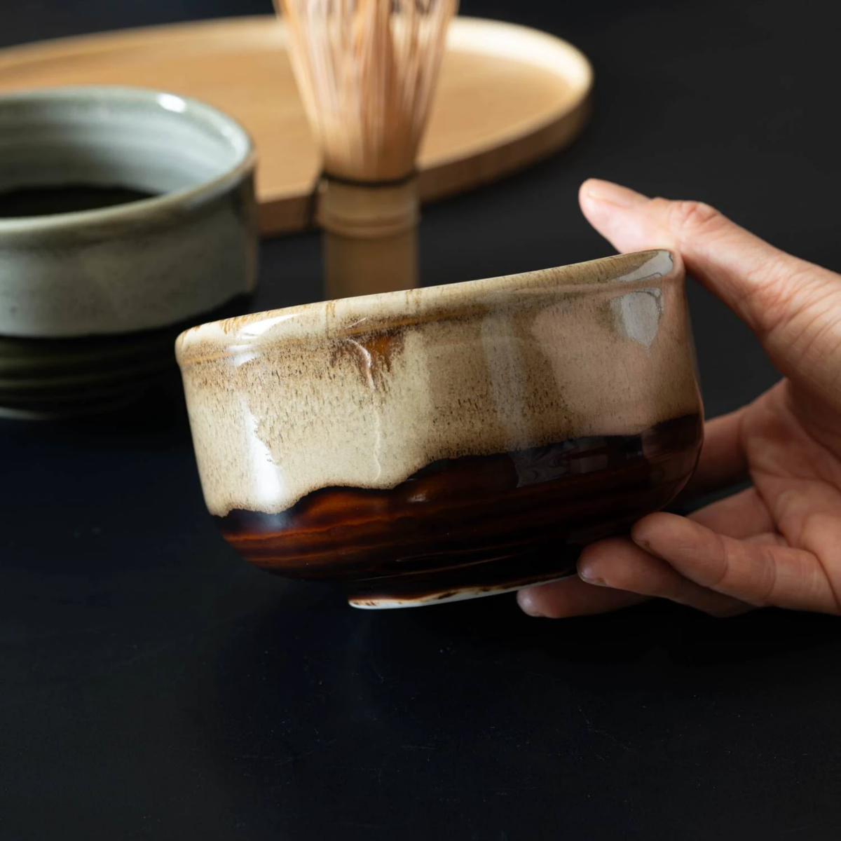 Fathom Japanese Mino Ware Matcha Bowl Miyajima Amber Ceramic, hand-crafted with a rich, lustrous glaze, shown held side view.