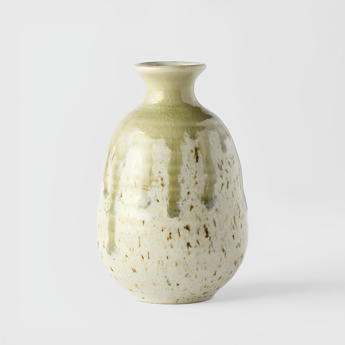 Side view of Fathom Japanese Sake Jug in light green, ceramic with drip glaze, rounded body and narrow neck for smooth pouring.