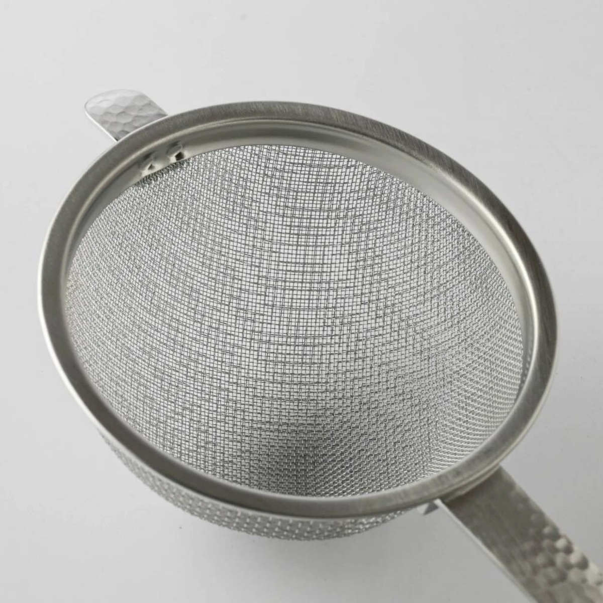 Close up on the head of Fathom Japanese Tea Strainer Silver Stainless Steel, flat design strains tea leaves and matcha powder.