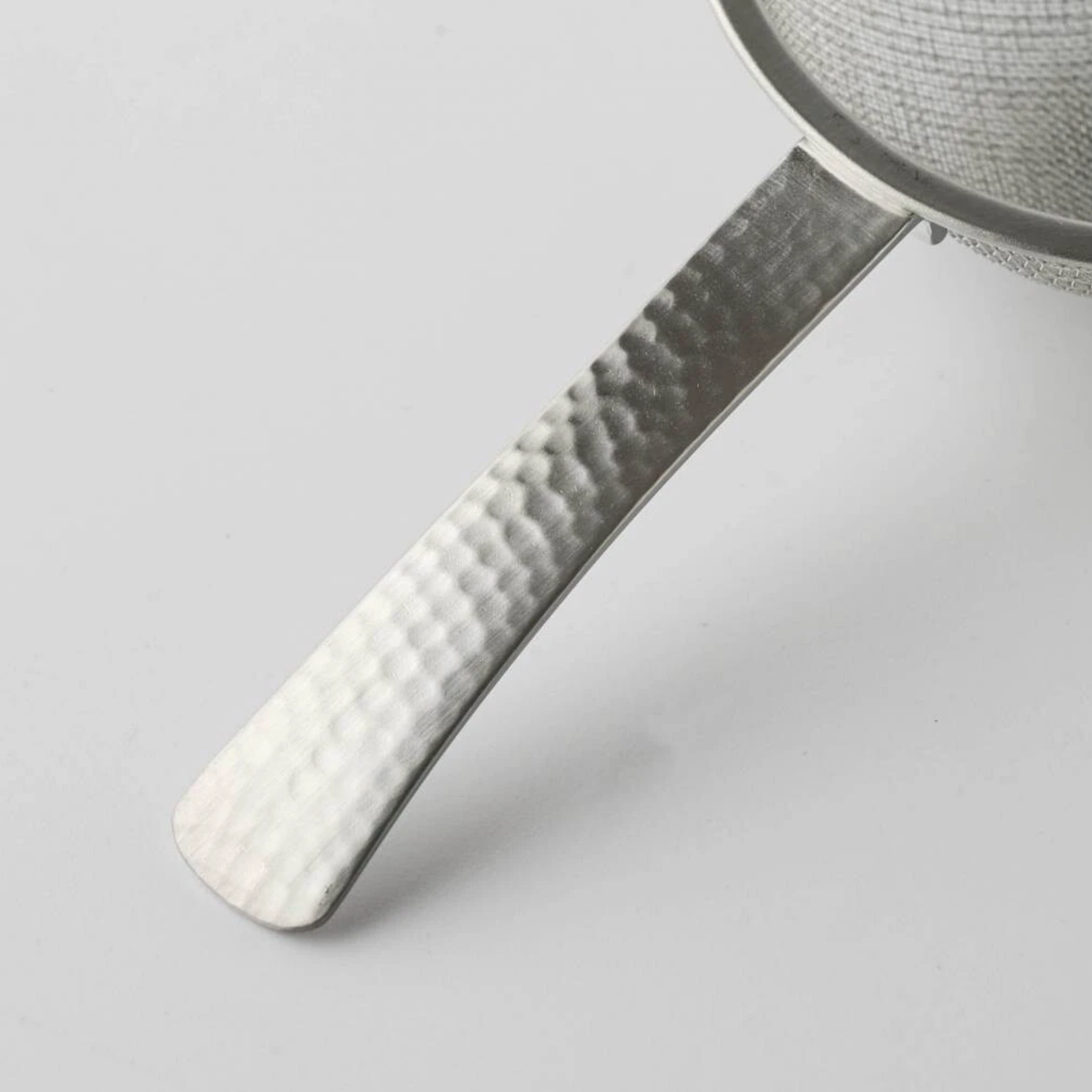 Close up on the handle of Fathom Japanese Tea Strainer Silver Stainless Steel, flat design strains tea leaves and matcha powder.