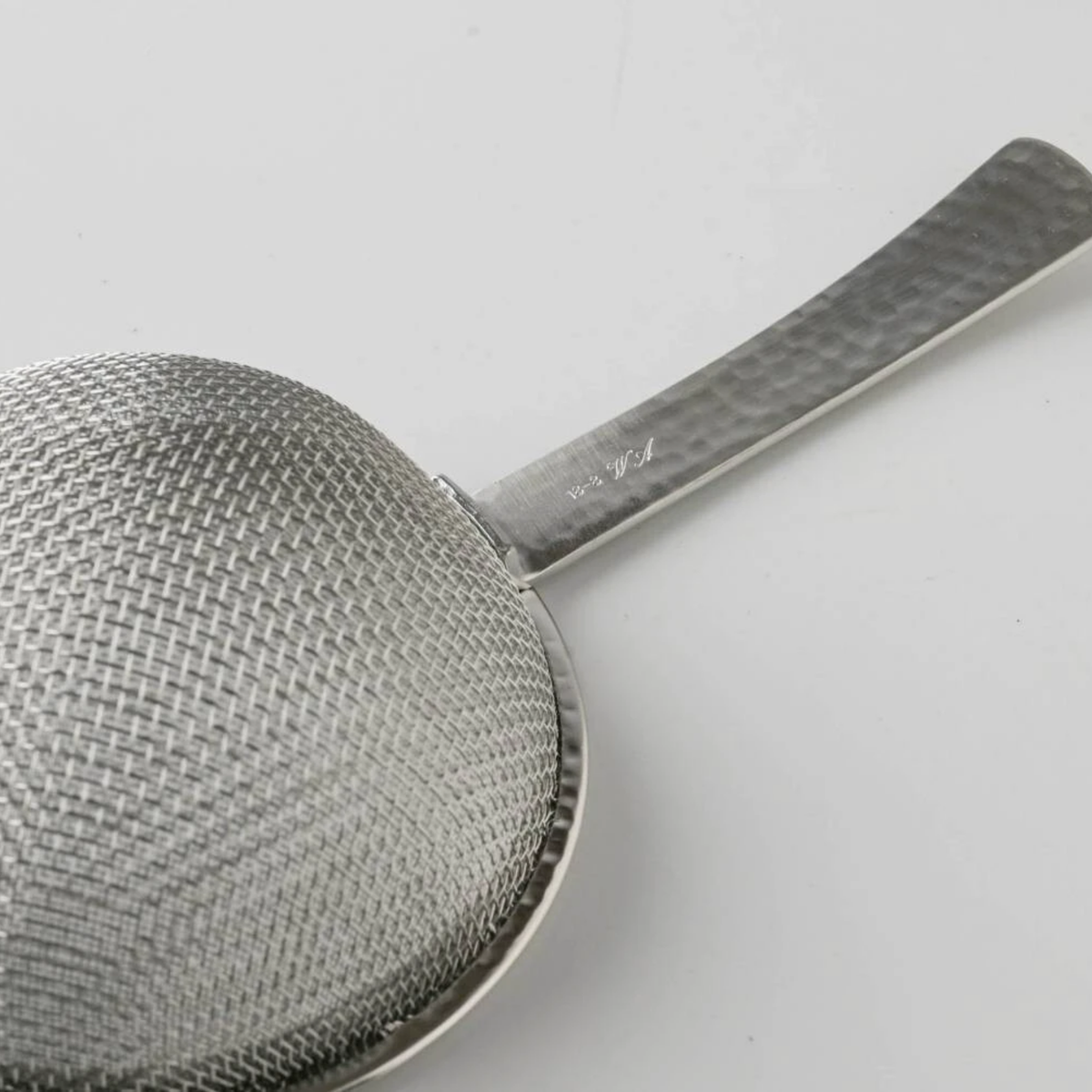 Close up on the back view of the Fathom Japanese Tea Strainer Silver Stainless Steel, flat design strains tea leaves and matcha powder.