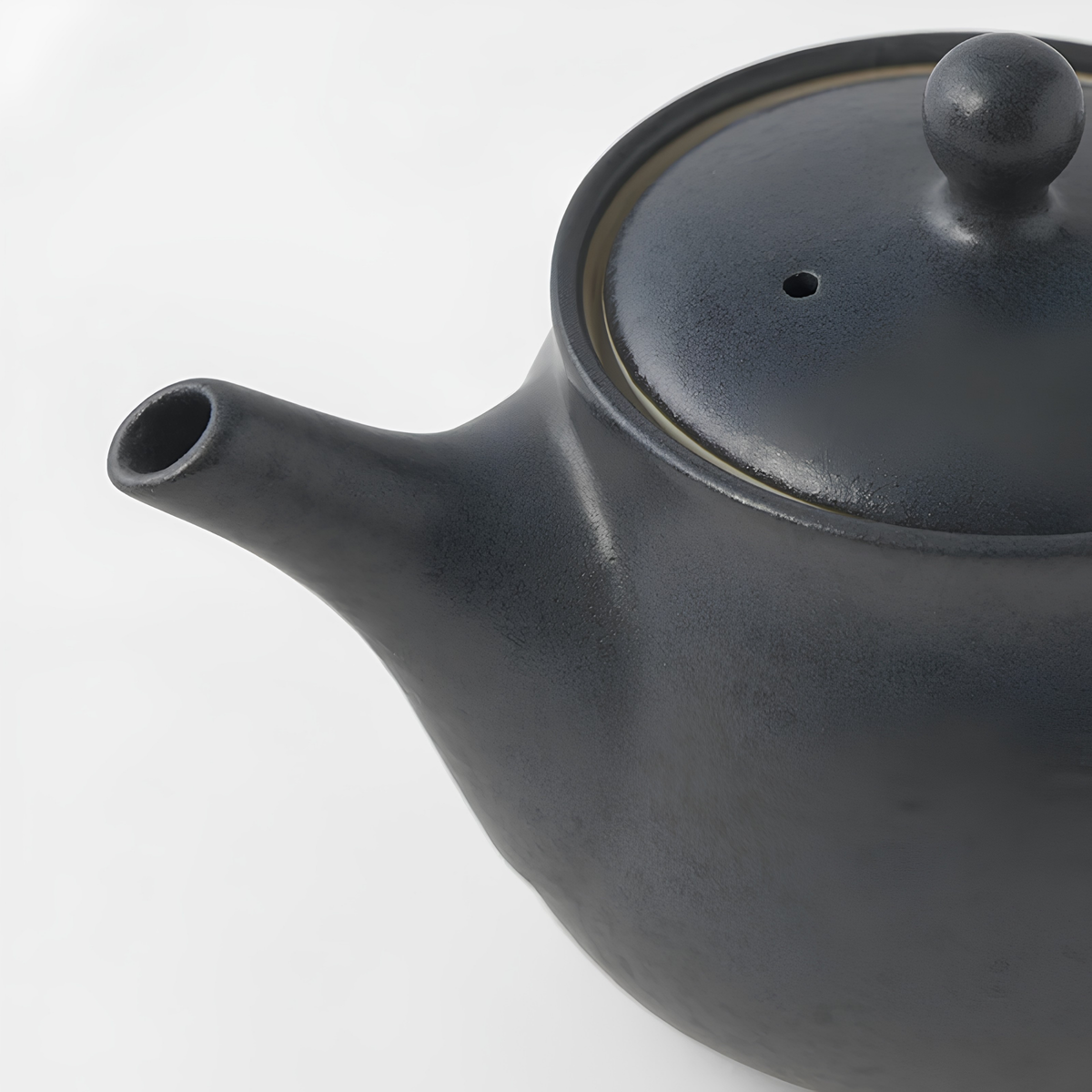 Close up semi top view of the Fathom Japanese Teapot in matt black, ceramic with satin glaze, rounded form and graceful spout for smooth pouring.