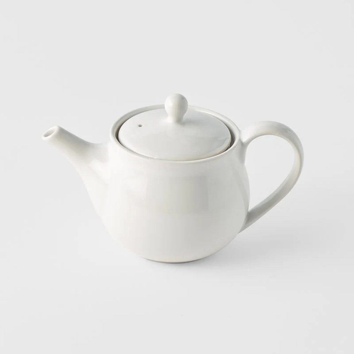 Side view of Fathom Japanese Teapot in matt white, ceramic with stainless steel infuser, 400ml capacity and smooth-pouring spout.