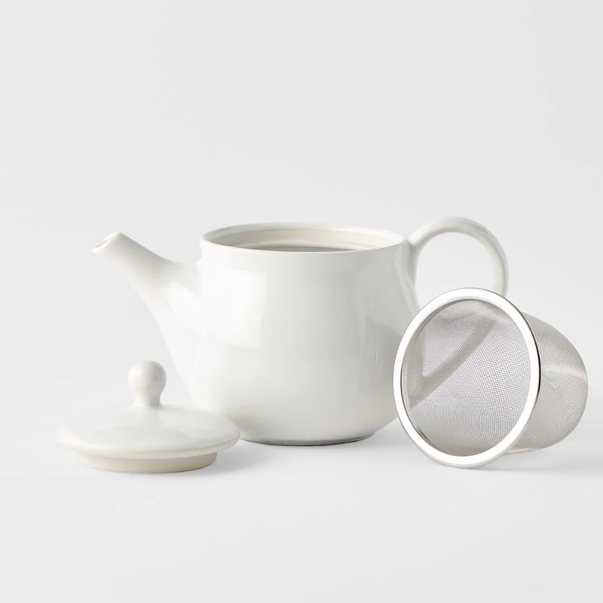 Showing the teapot, lid and strainer from the Fathom Japanese Teapot in matt white, ceramic with stainless steel infuser, 400ml capacity and smooth-pouring spout.