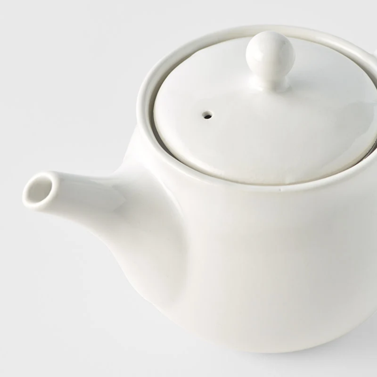 Close up semi top view of the Fathom Japanese Teapot in matt white, ceramic with stainless steel infuser, 400ml capacity and smooth-pouring spout.