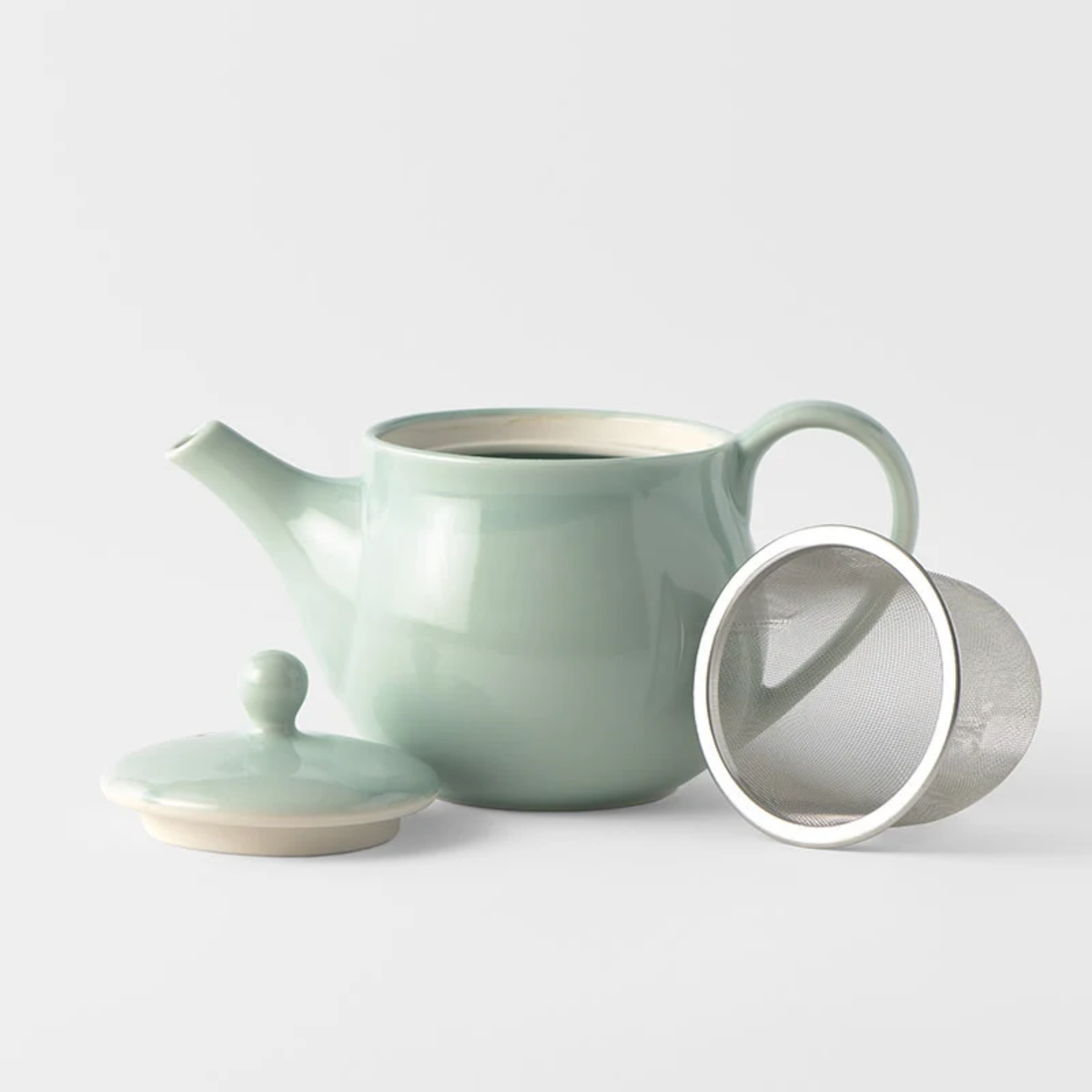 Showing the teapot, lid, and strainer from Fathom Japanese Teapot in light green, ceramic with smooth Tomei glaze, 400ml capacity and balanced form for smooth pouring.