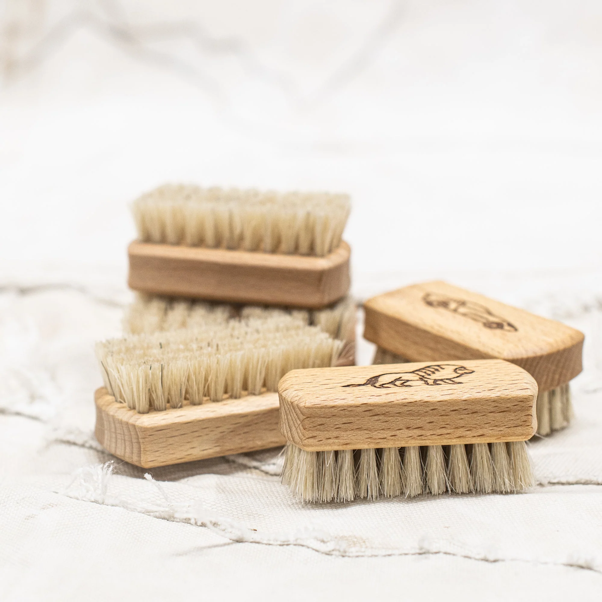 Children's nail brushes by Fathom, made from beechwood with soft bristles and wooden handle with engraved object designs.