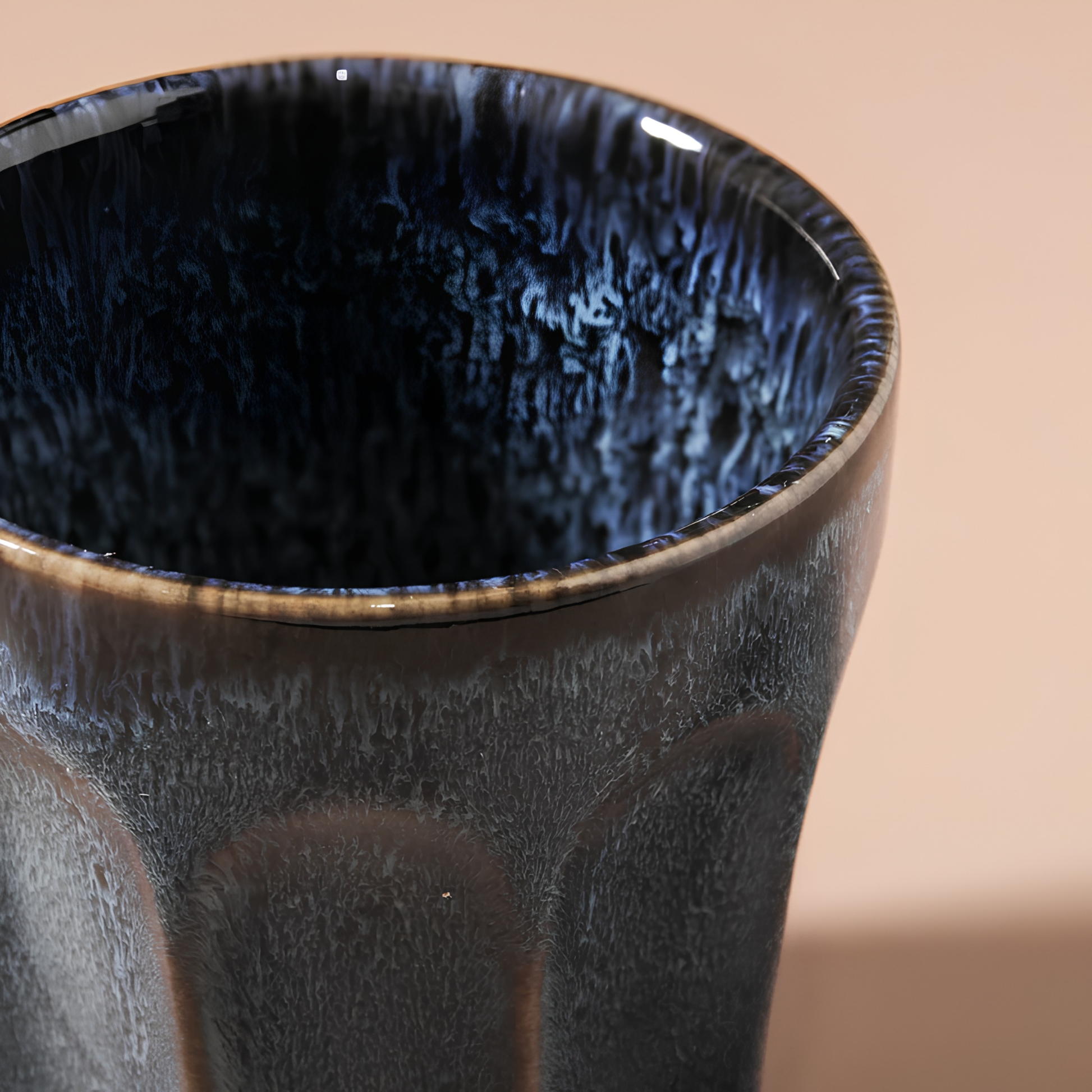 Close up on the inside of the Fathom Latte Cup Navy stoneware that is handcrafted with reactive glazes of earthly hues finish.