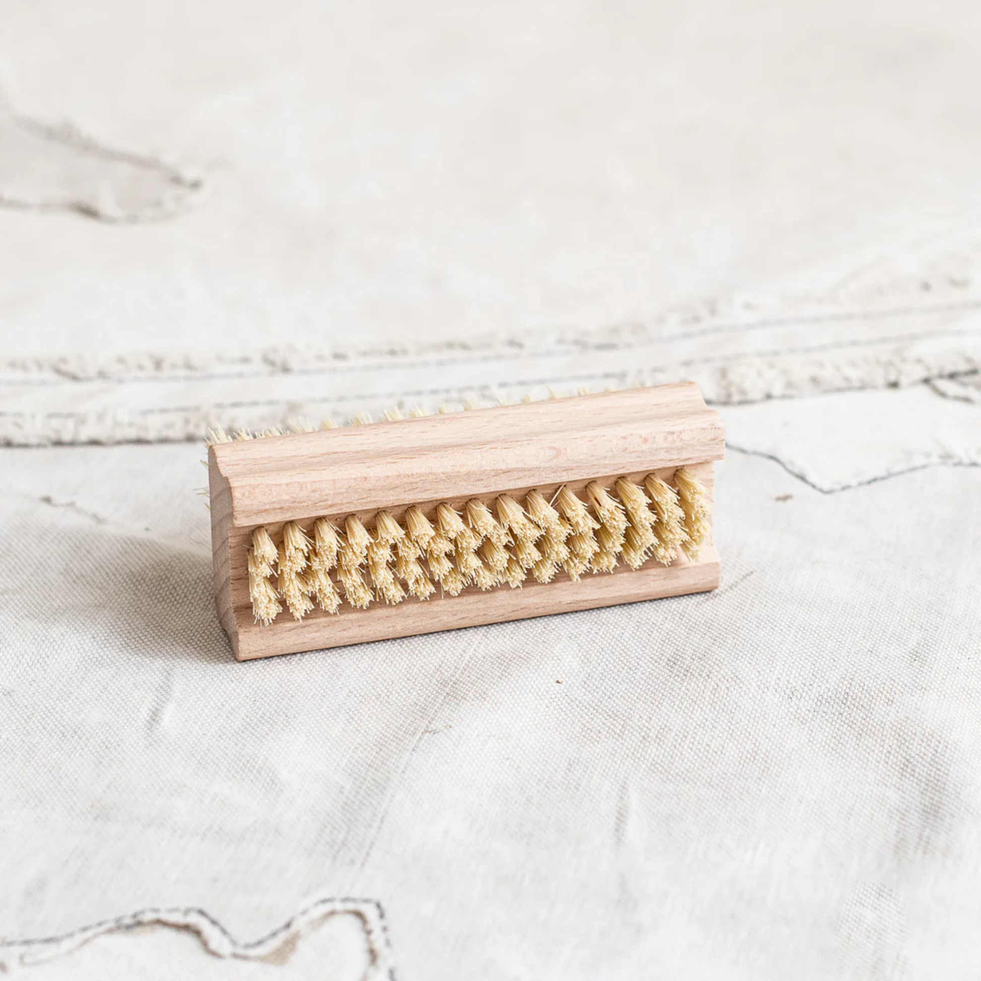 Side view showing the lesser brush side from Fathom Nail Brush, German-made double-sided beechwood with agave fiber, durable firm brush for cleaning nails and hands.