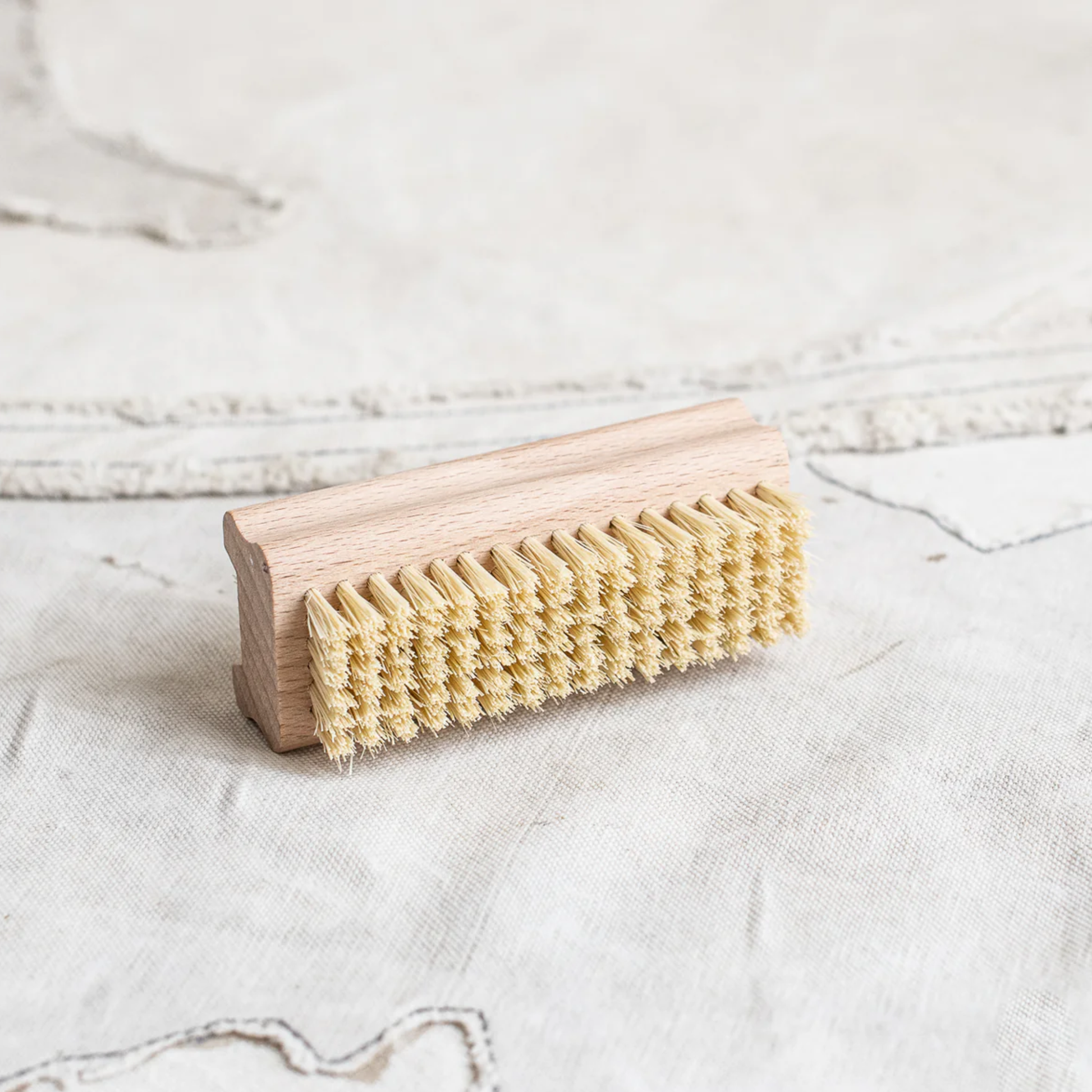 Side view showing the greater brush side from Fathom Nail Brush, German-made double-sided beechwood with agave fiber, durable firm brush for cleaning nails and hands.