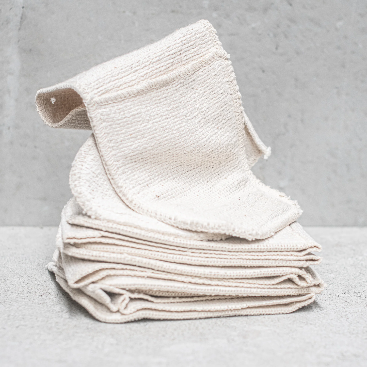 A pile of folded Fathom Oven Mitts Heat Resistant with 70cm length, full-length arm coverage for deeper ovens and larger roasting trays