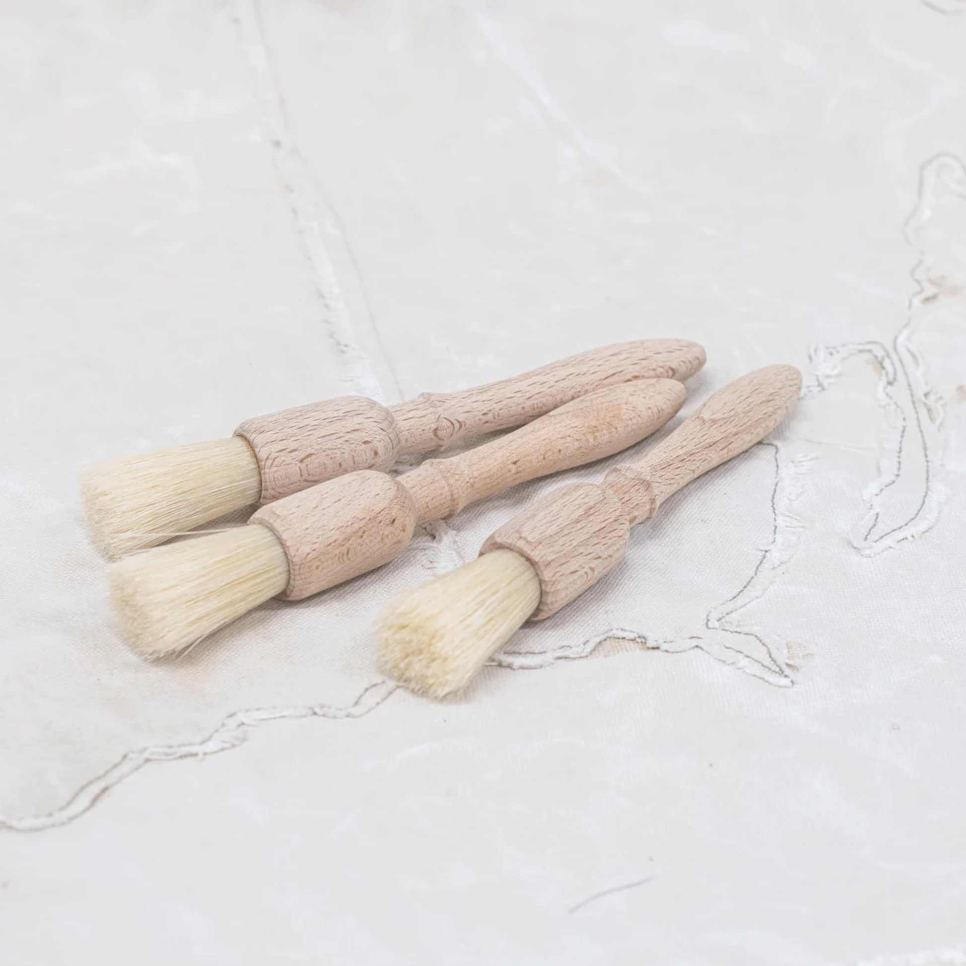 Showing on a surface a group of Fathom Large Pastry Brushes, German-made natural bristles, 19cm round pastry brush, ideal for baking and basting.