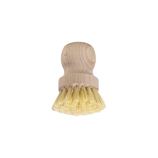 Upside down view of Fathom Pot Brush Tampico Fibre- Raw beechwood brushes with stiff bristles rest on textured fabric.