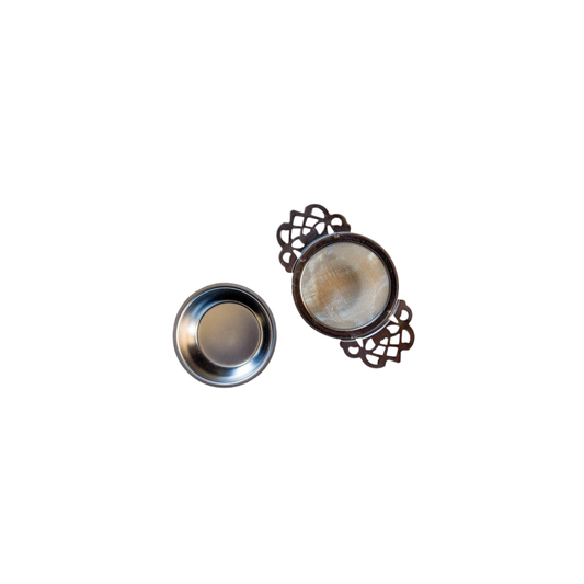 Tea strainer and drip tray side by side top view
