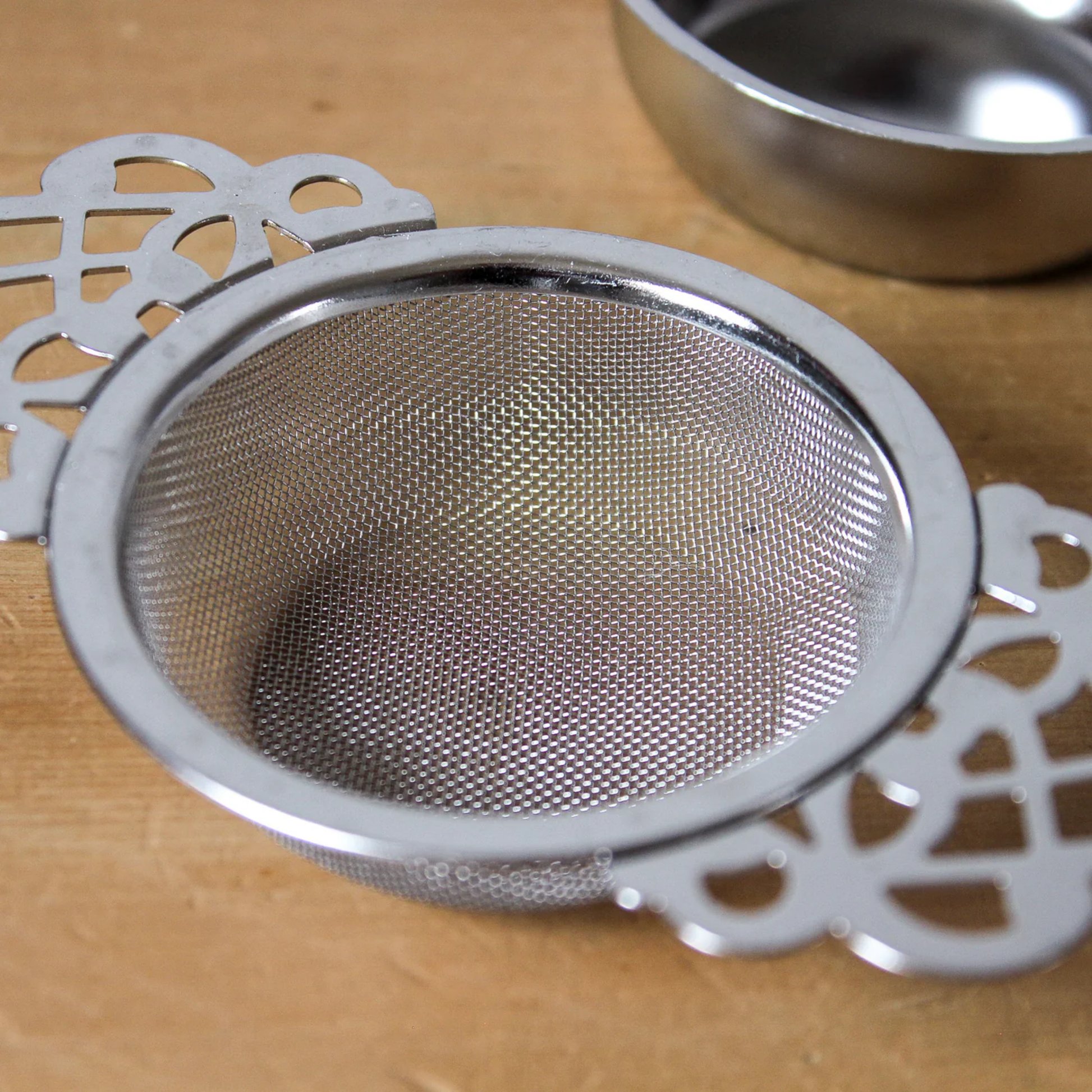 Close up of tea strainer on wooden table 