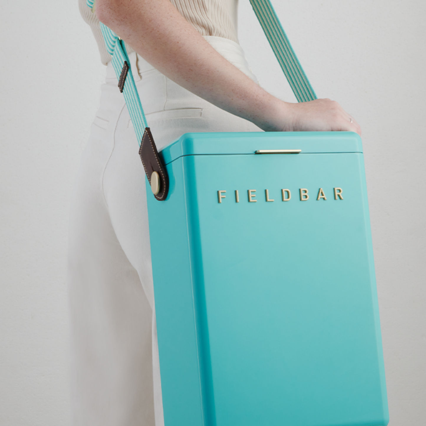 Shoulder carried FIELDBAR Drinks Box Swing Sling, Bazaruto blue and Safari white, adjustable from 94.5cm to 147cm, genuine leather, comfortable on shoulder, shown attached with the cooler.