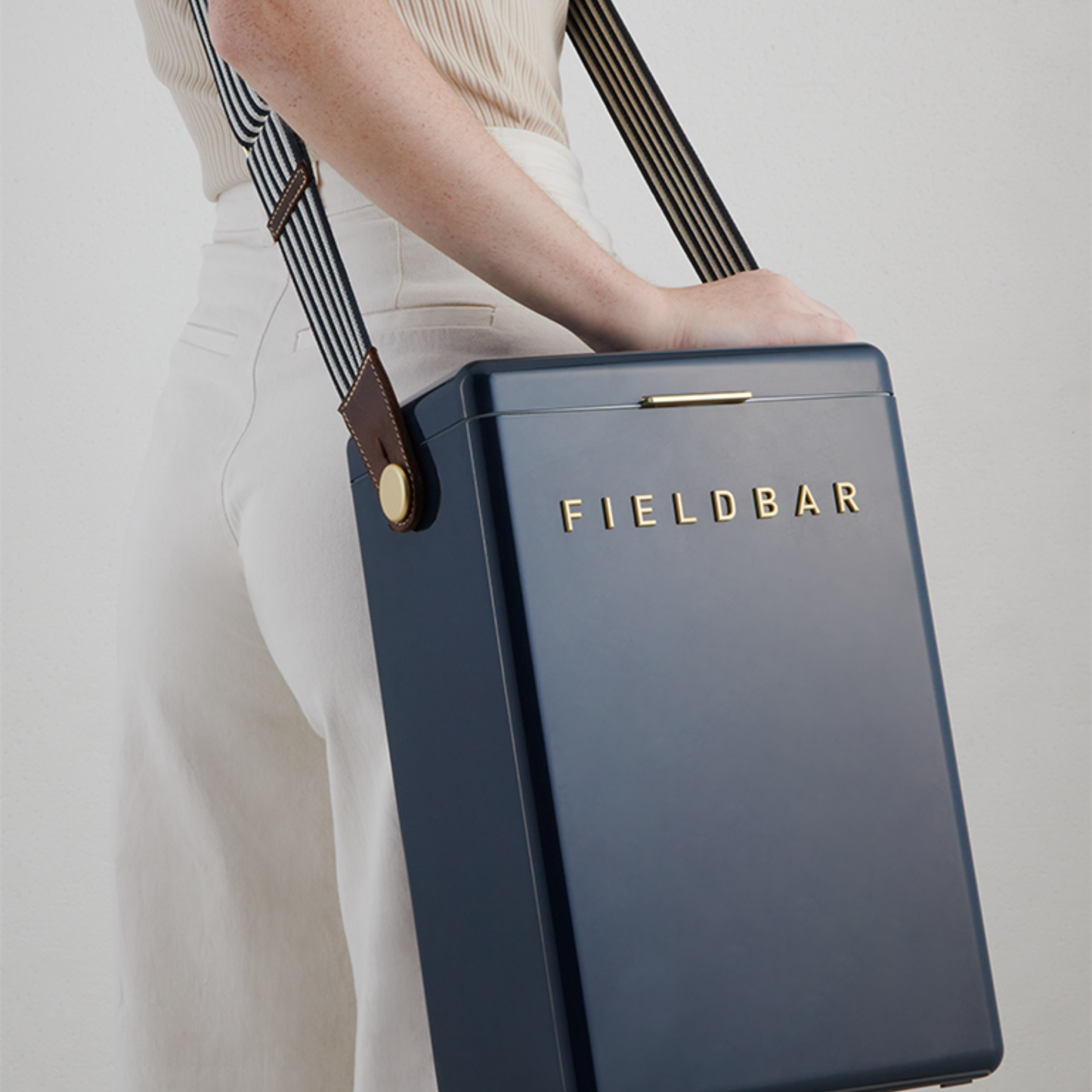 Shoulder carried FIELD BAR Drinks Box Swing Sling, Sea boat blue and Safari white, adjustable from 94.5cm to 147cm, genuine leather, comfortable on shoulder, shown attached with cooler.