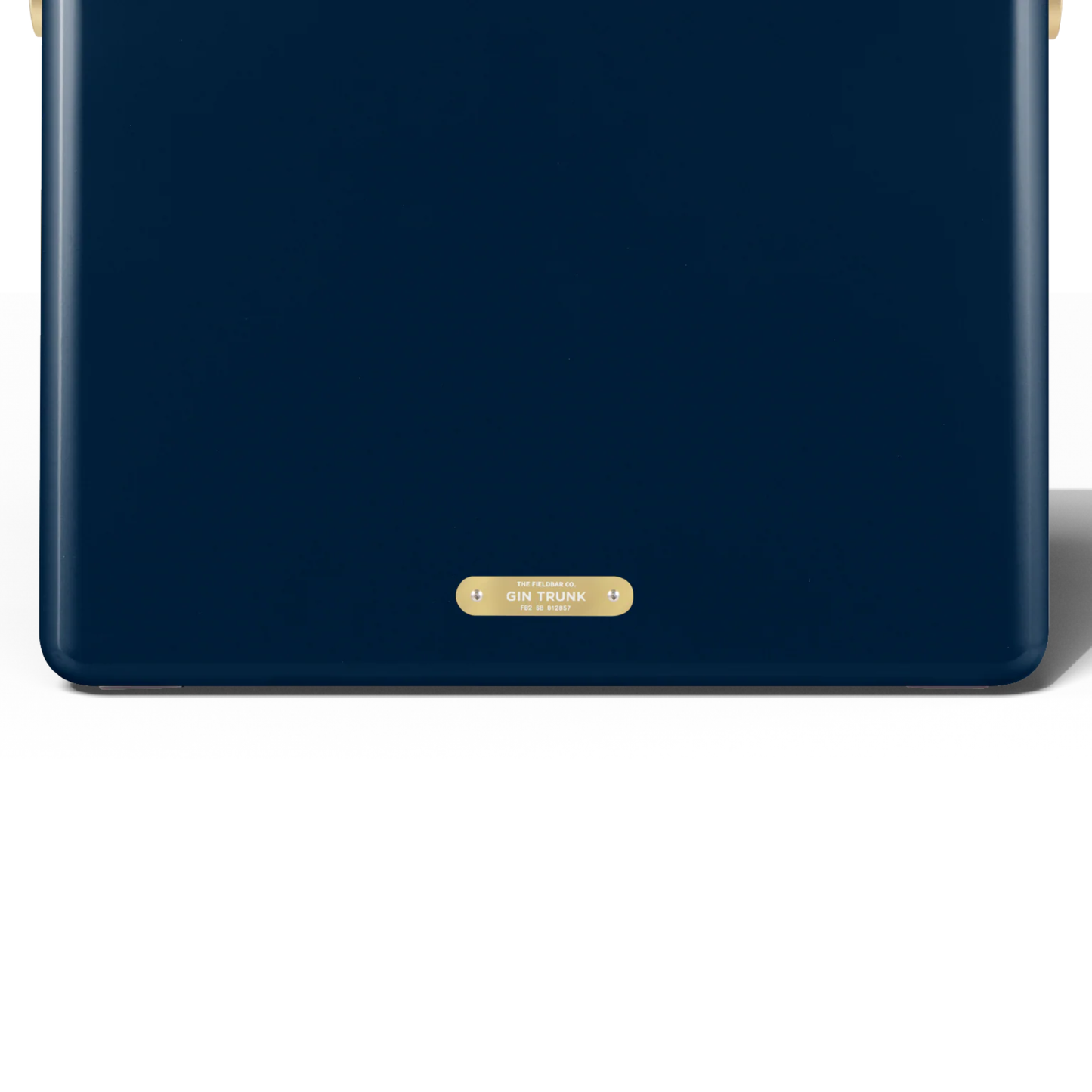 Backview with the badge that has Gin Trunk lettering from FIELDBAR Gin Trunk Sea Boat Blue - premium hardcase 24L insulated cooler box in blue impact-resistant material with leather-wrapped handle, extruded aluminum carry handle, reflective heat-reducing paint, airtight water- and air-sealed gasket, BPA-free easy-clean interior, removable high-performance insulation, and 50-hour ice retention.