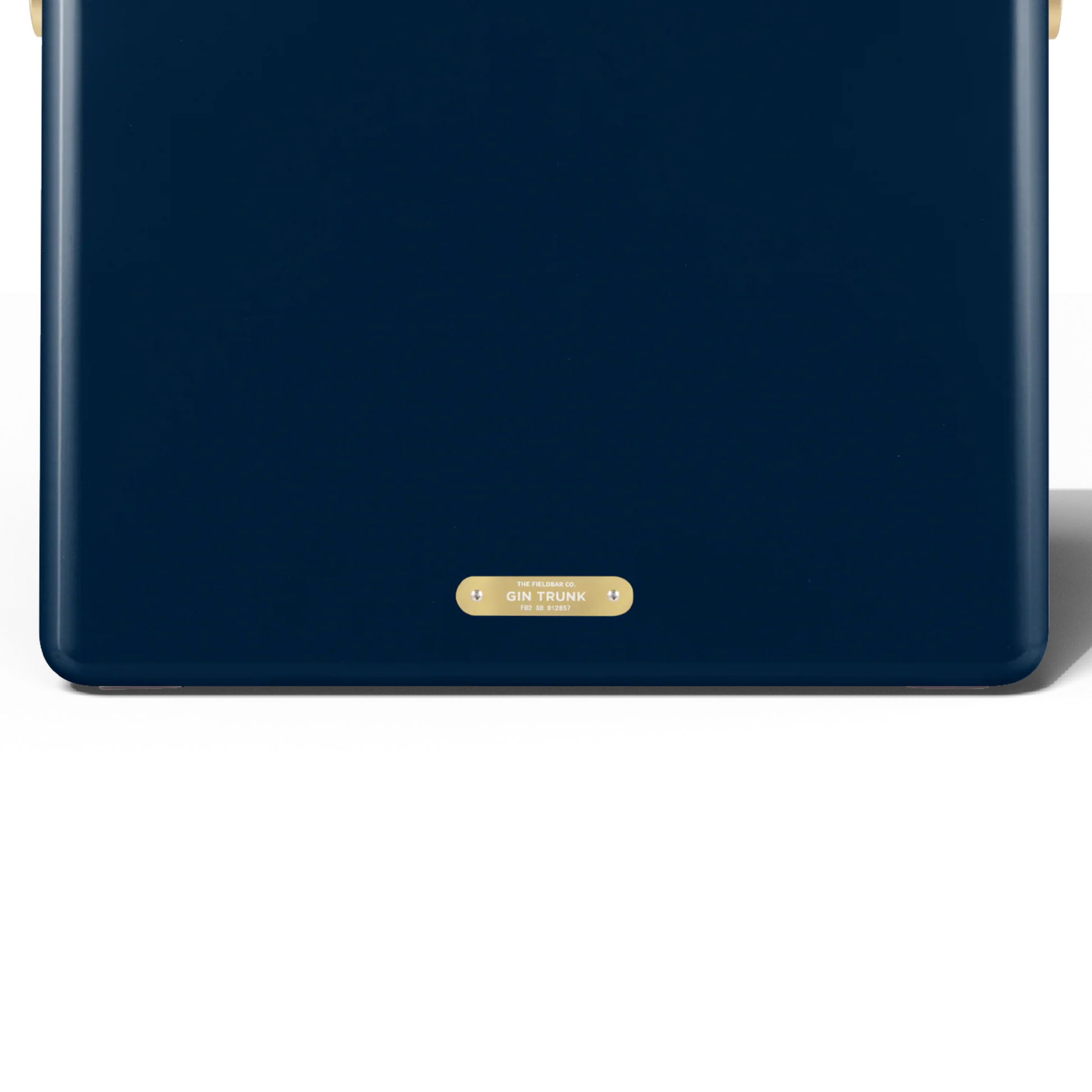 Backview with the badge that has Gin Trunk lettering from FIELDBAR Gin Trunk Sea Boat Blue - premium hardcase 24L insulated cooler box in blue impact-resistant material with leather-wrapped handle, extruded aluminum carry handle, reflective heat-reducing paint, airtight water- and air-sealed gasket, BPA-free easy-clean interior, removable high-performance insulation, and 50-hour ice retention.