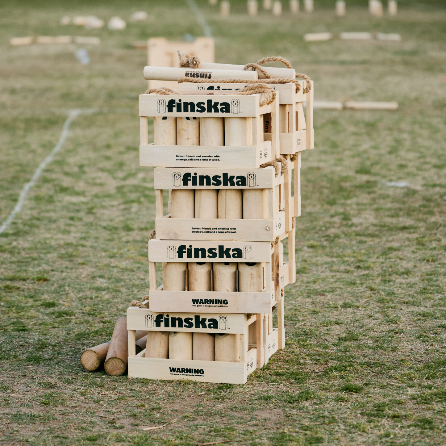Stacked Original Finska natural birch outdoor throwing game set, includes 12 numbered pins, a Finska throwing log, birch carry crate, rule card, and score sheet. Traditional Finnish lawn game promoting strategy, skill, and fun for all ages.