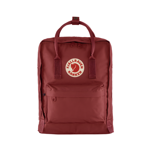 Front view of The Fjallraven Kanken Ox Red Backpack made from hard-wearing Vinylon F fabric and features a spacious main compartment with a full-length zip, removable PE foam seat cushion, two flat side pockets, a zipped front pocket, adjustable shoulder straps, and top handles. Designed for school, work, trekking, and travel, it includes a reflective logo and an internal address label, making it a durable and practical backpack for everyday use.