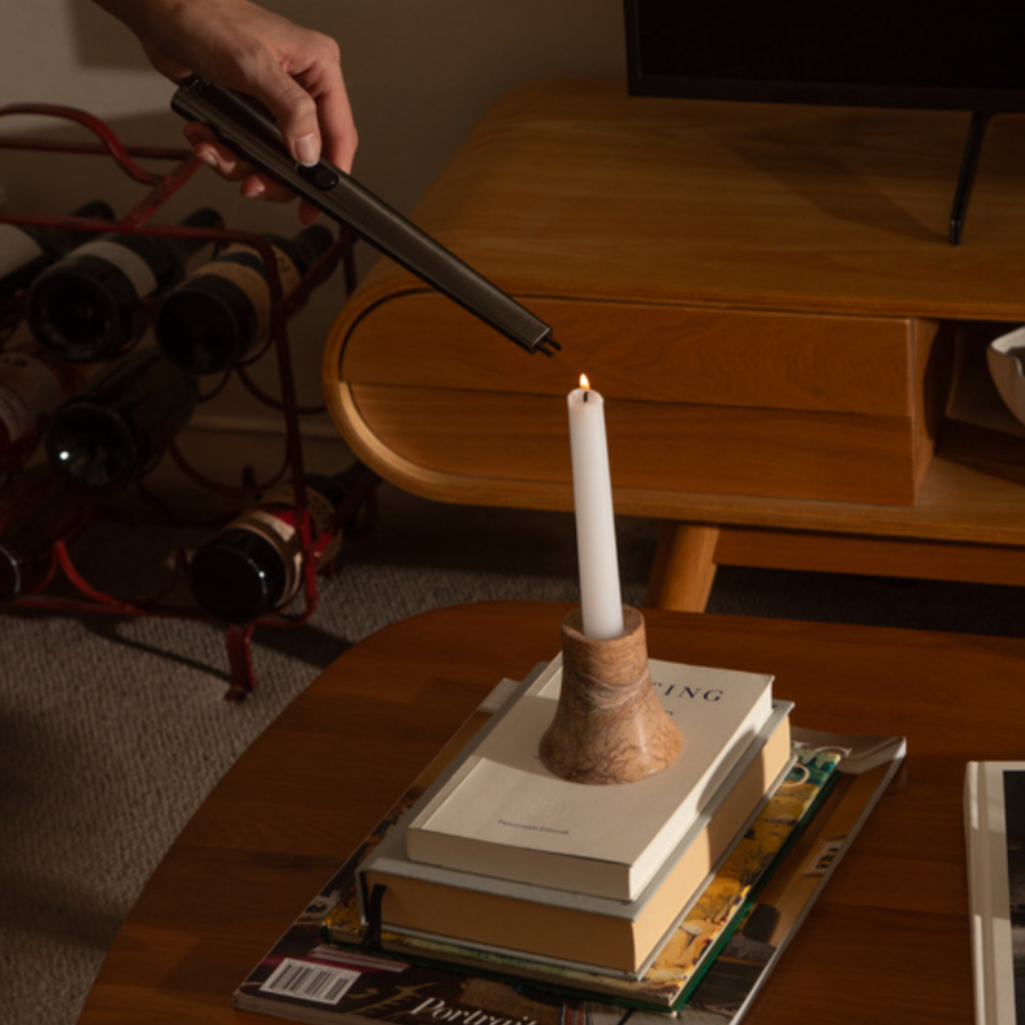 Flint rechargeable gunmetal lighter lighting candle in livingroom setting