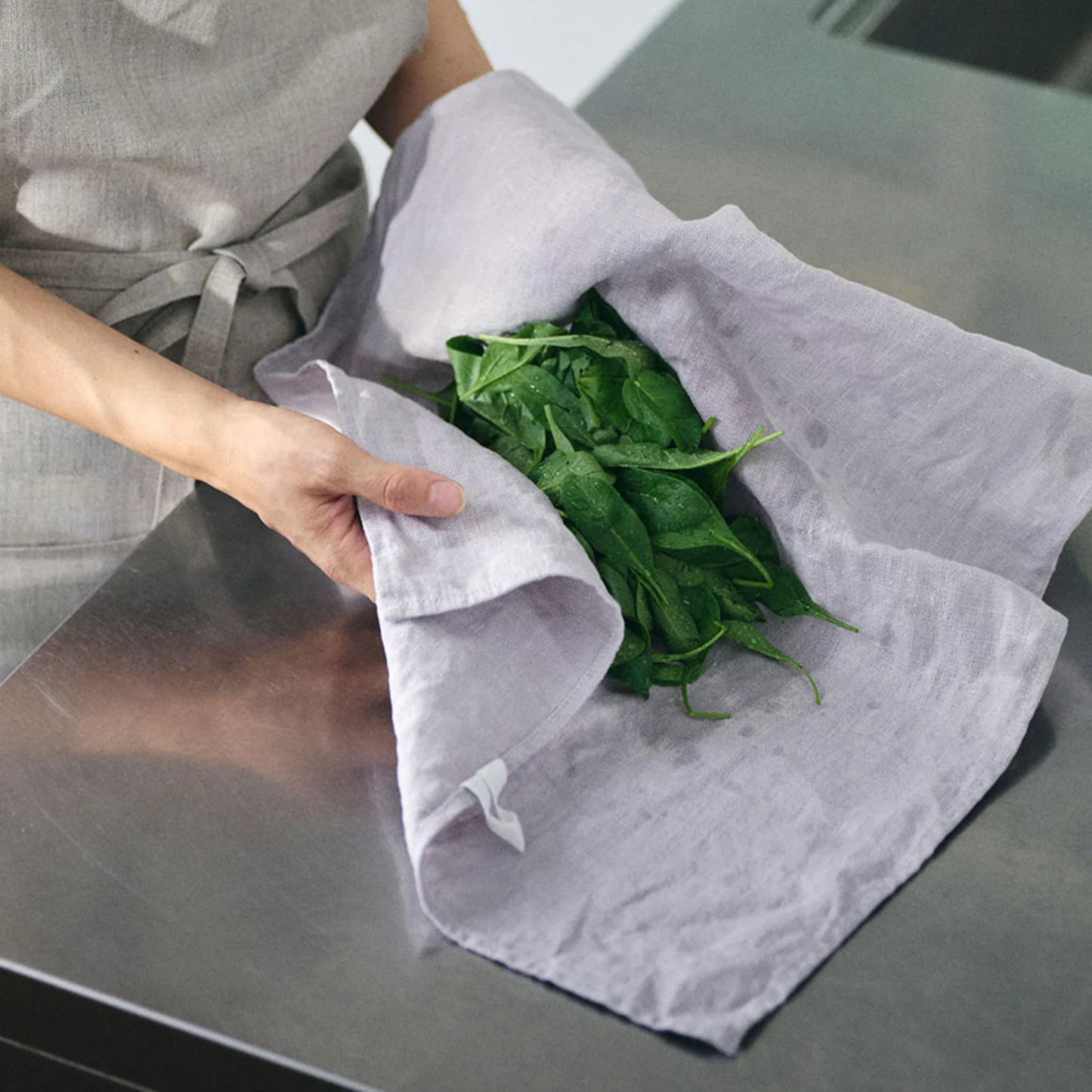 Fog Linen cloth tea towel ice grey drying spinach on stainless steel countertop