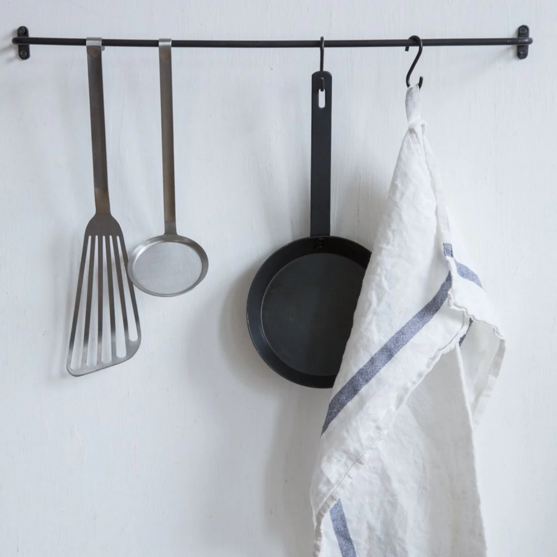 Fog Linen cloth tea towel lined navy hanging on pot rack with kitchen utensils