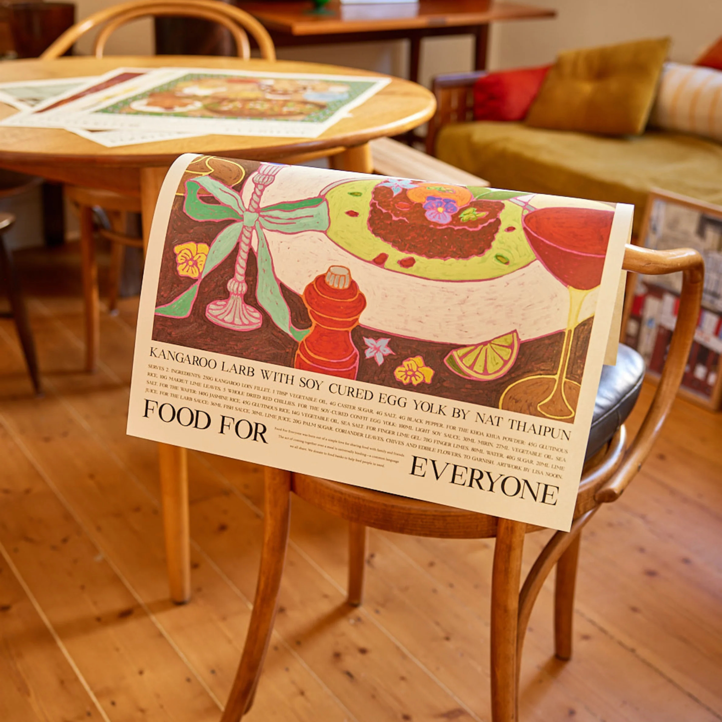 Food For Everyone Poster A2 Kangaroo Larb in a dinner party scene which is the dish that won on MasterChef Australia by Nat Thaipun resting on a chair.