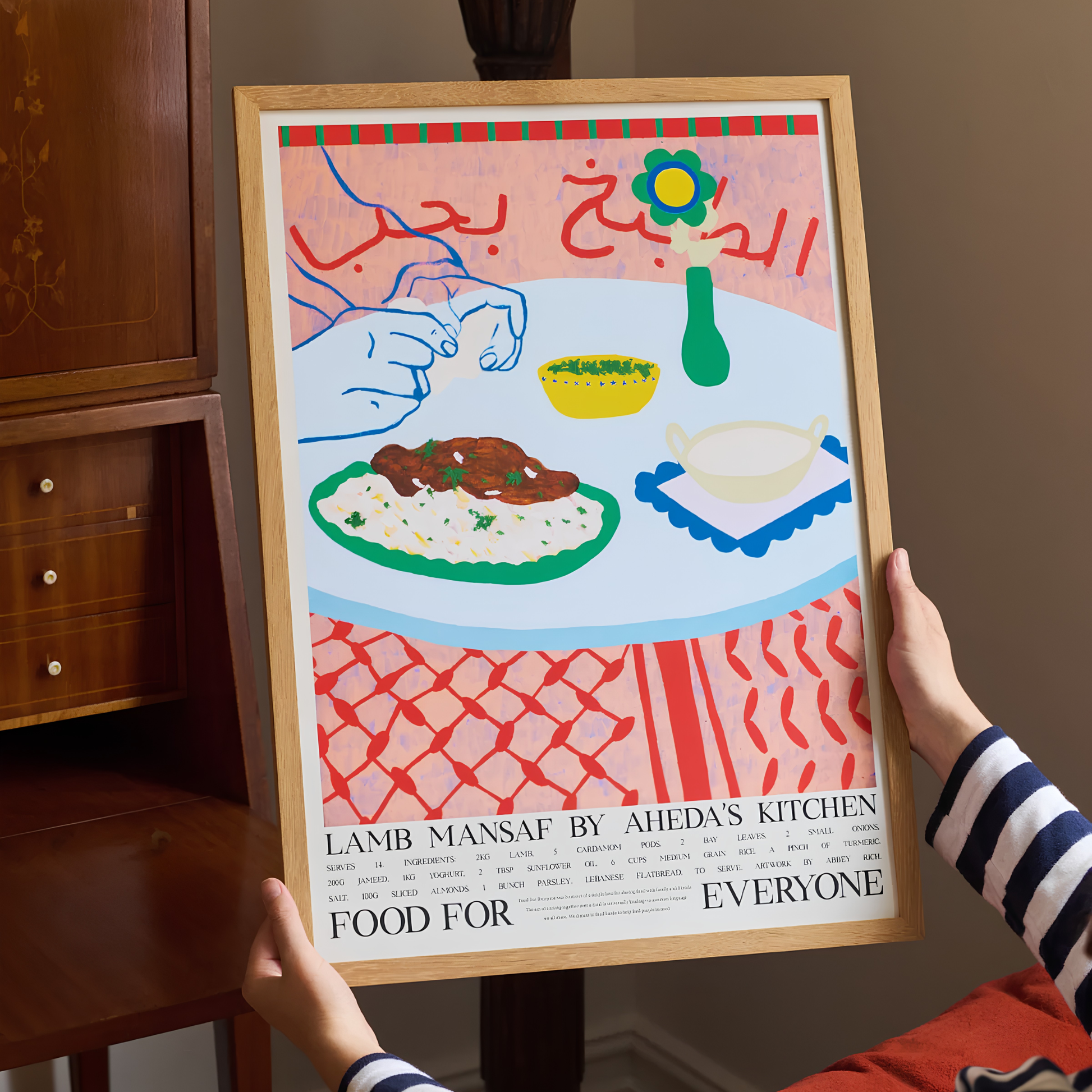 Front view of the Food For Everyone Poster A2 Lamb Mansaf held by hands, an illustration of a spiced slow-cooked lamb with rice and a tangy jameed yoghurt sauce with recipe.