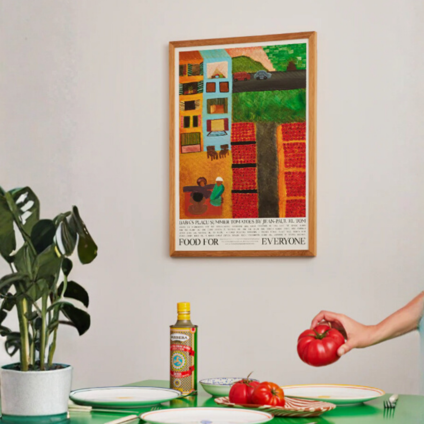 Hung on the dining area wall Food for Everyone Limited Edition Baba's Place Poster A2 printed on recycled coffee cup paper, featuring Rahma Soliman's warm summer illustration inspired by chef Jean-Paul El Tom's tomato recipe; unframed