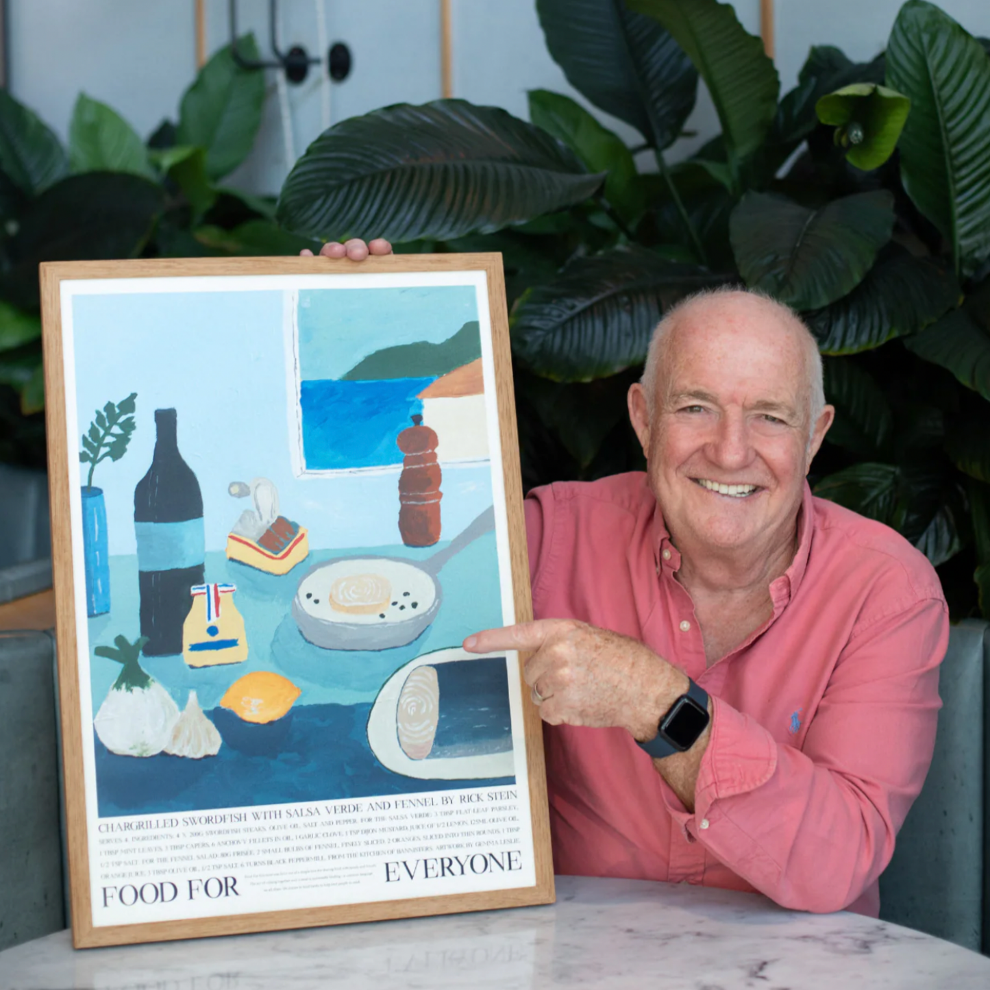 Man holding Food For Everyone Chargrilled Swordfish artwork A2 front in frame in kitchen