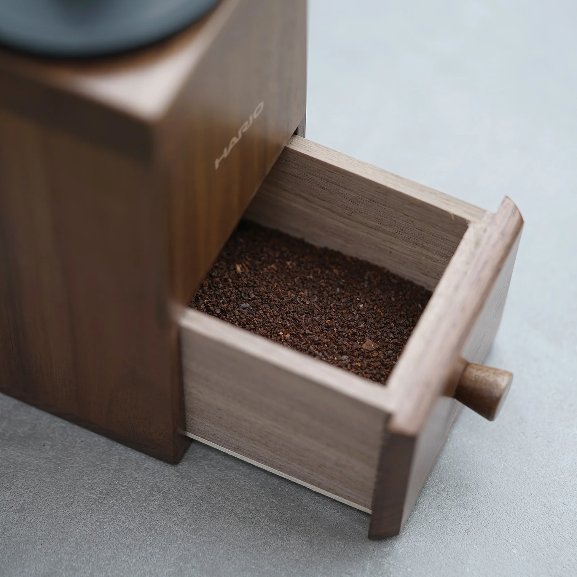 Showing the drawer with the ground coffee using the Hario Coffee Mill Cube 3-4 cups wooden coffee grinder with ceramic burr and stainless steel handle.