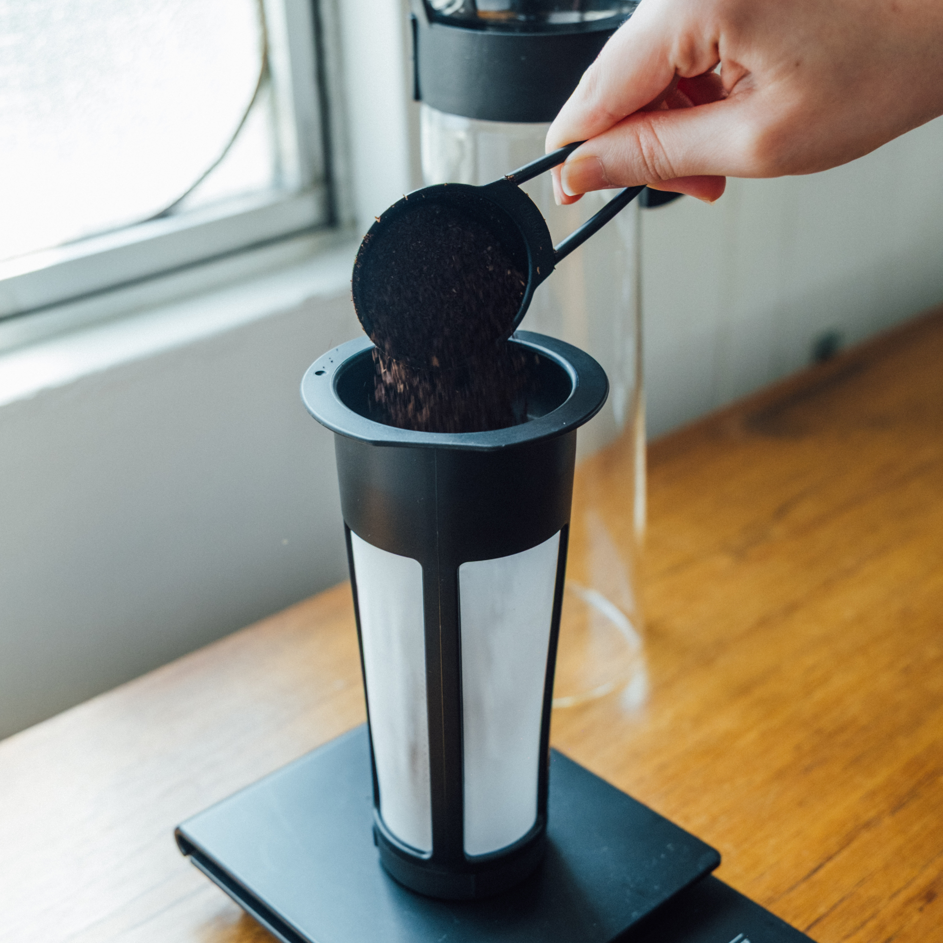 Coffee put in the strainer of the Hario Cold Brew Coffee Pot Glass Black that is made from a durable heatproof Hario glass, foolproof design with 1L capacity.