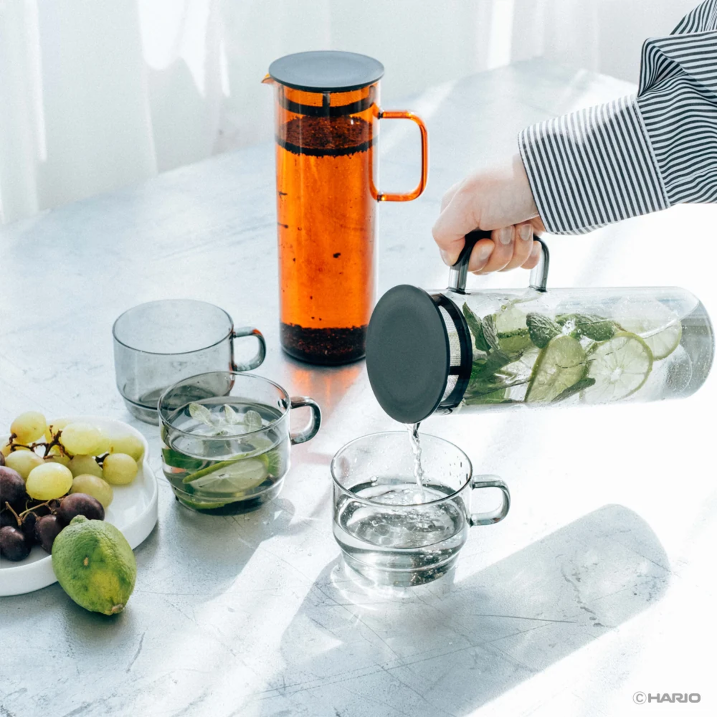 On the table with glasses and the Hario Glass Pitcher Amber that is made from heatproof glass with 800ml capacity, with a lid that has a mesh filter.